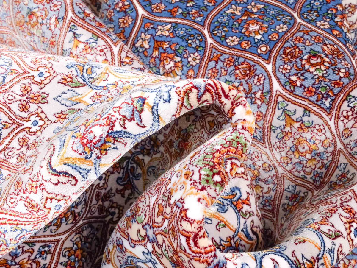 Ghom Maschinenteppich "Rudabeh" 180 x 120 cm, mit Medaillon, aus pflanzlicher Seide (Viskose), Cremeweiß-Blau. Teppichnummer: V72CR216H. Persian Luxury Collection by Khademi. Made in Iran / Persia – Vertrieb durch JUPITER Intl.