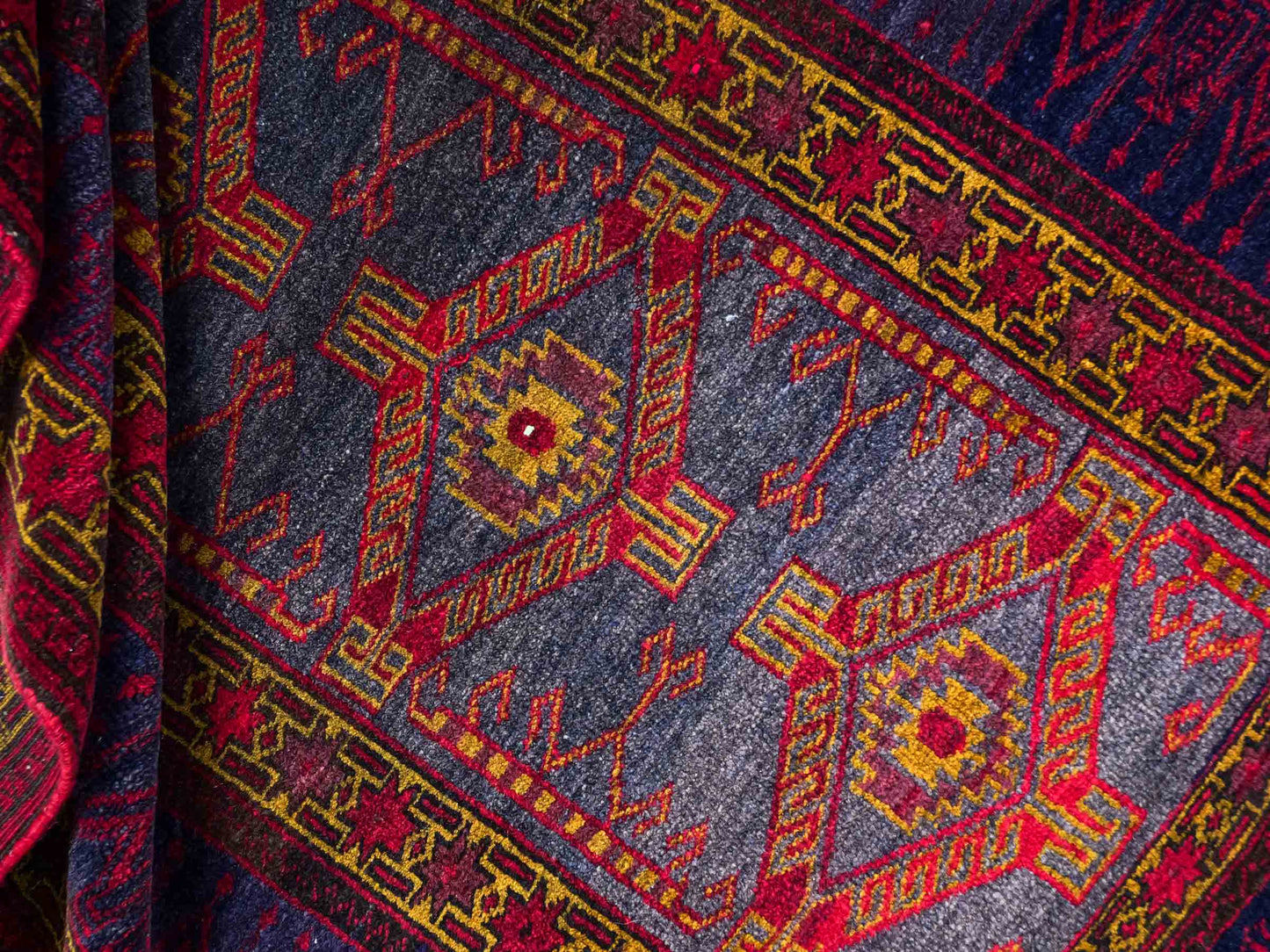 Antiker, handgeknüpfter, afghanischer Belutsch Nomadenteppich aus Wolle von Khademi. Größe: 122 x 82 cm. Farbe: Blau, rot, gold. Verkauf durch JUPITER Intl.