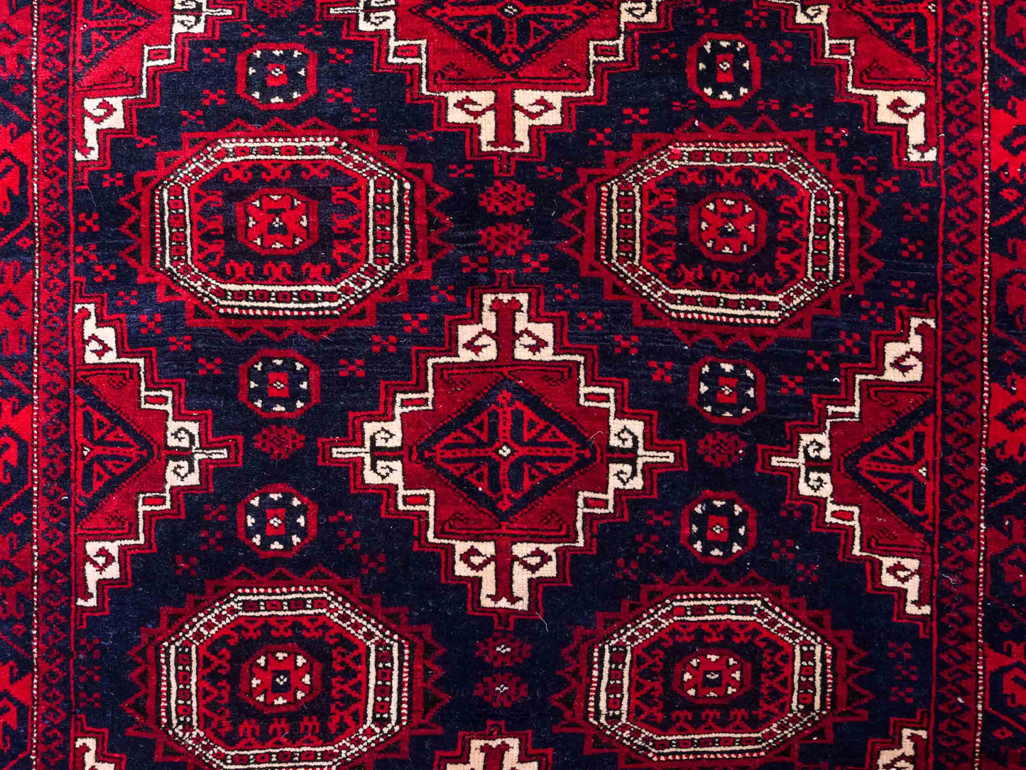 Handgeknüpfter, afghanischer Belutsch Nomadenteppich aus Wolle von Khademi. Größe: 173 x 117 cm. Farbe: Rot, blau. Verkauf durch JUPITER Intl.