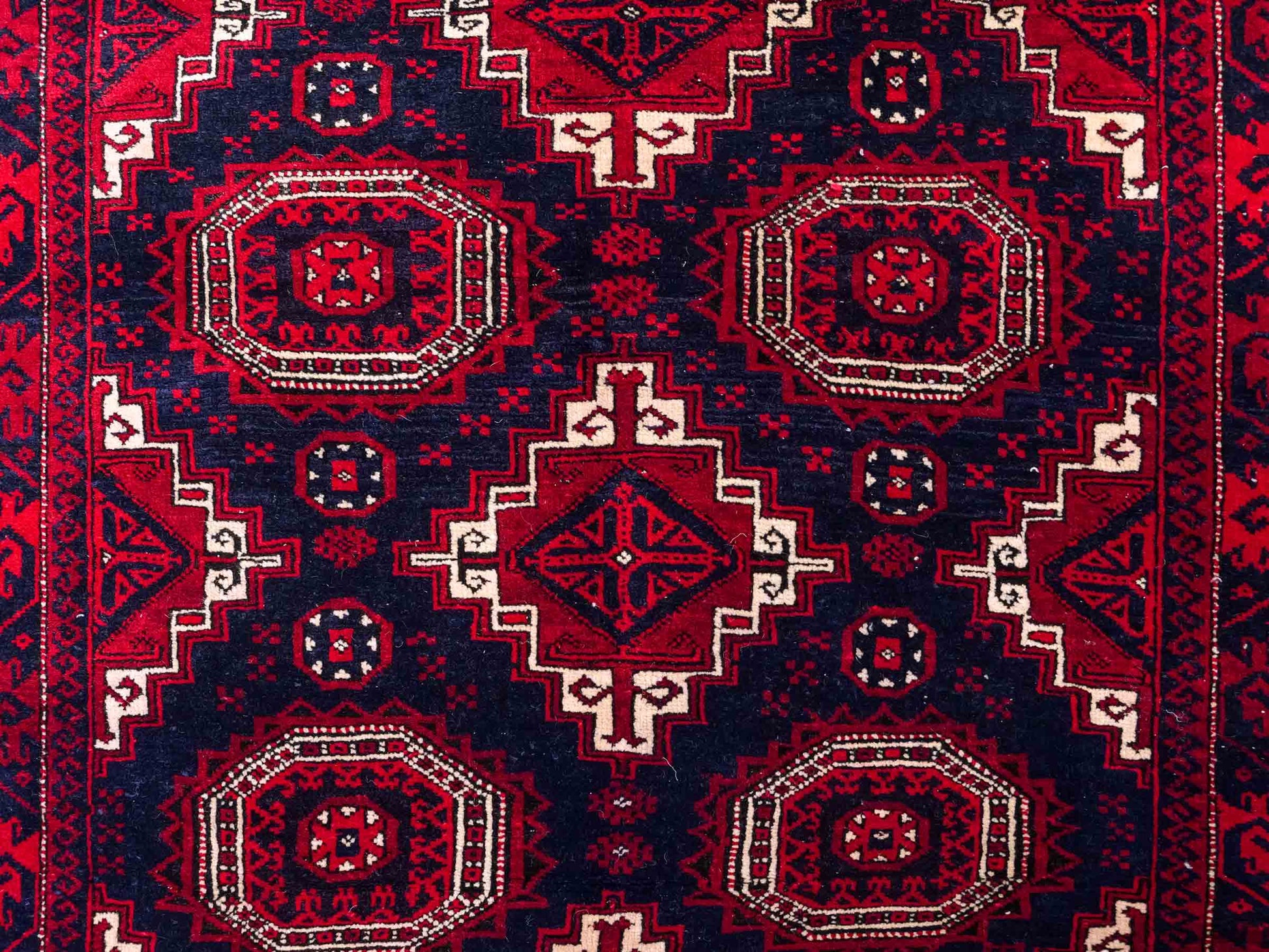Handgeknüpfter, afghanischer Belutsch Nomadenteppich aus Wolle von Khademi. Größe: 173 x 117 cm. Farbe: Rot, blau. Verkauf durch JUPITER Intl.