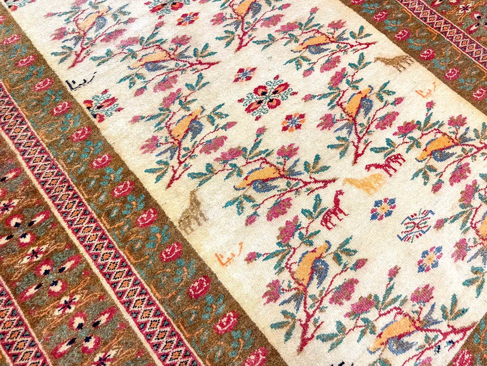 Antiker Mashhad aus reiner Wolle. Handgeknüpft. Ursprung Iran / Persien. Größe: 181 x 110 cm. Hauptfarben: Braun, Gelb, Gold mit roten und grünen Akzenten. Vertrieb durch JUPITER Intl / Khademi.