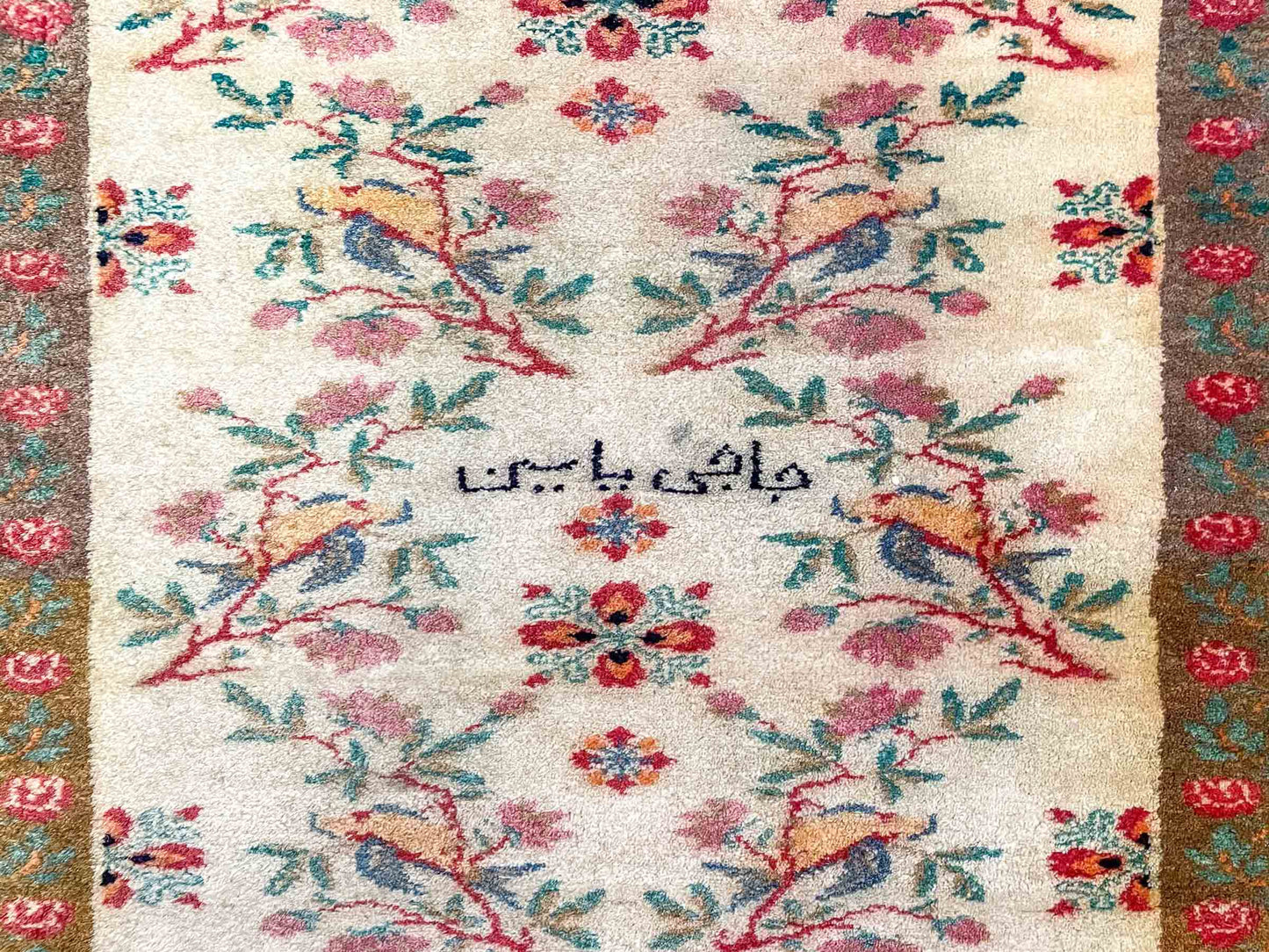 Antiker Mashhad aus reiner Wolle. Handgeknüpft. Ursprung Iran / Persien. Größe: 181 x 110 cm. Hauptfarben: Braun, Gelb, Gold mit roten und grünen Akzenten. Vertrieb durch JUPITER Intl / Khademi.
