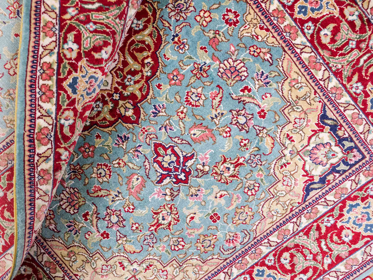 Sehr feiner, handgeknüpfter Khademi Orientteppich mit Ghom Design aus reiner Seide, blau, rot. 94x64 cm. Vertrieb durch Jupiter Intl.