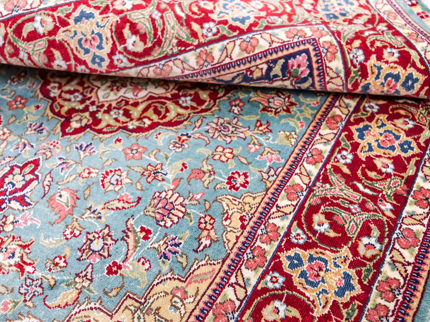 Sehr feiner, handgeknüpfter Khademi Orientteppich mit Ghom Design aus reiner Seide, blau, rot. 94x64 cm. Vertrieb durch Jupiter Intl.
