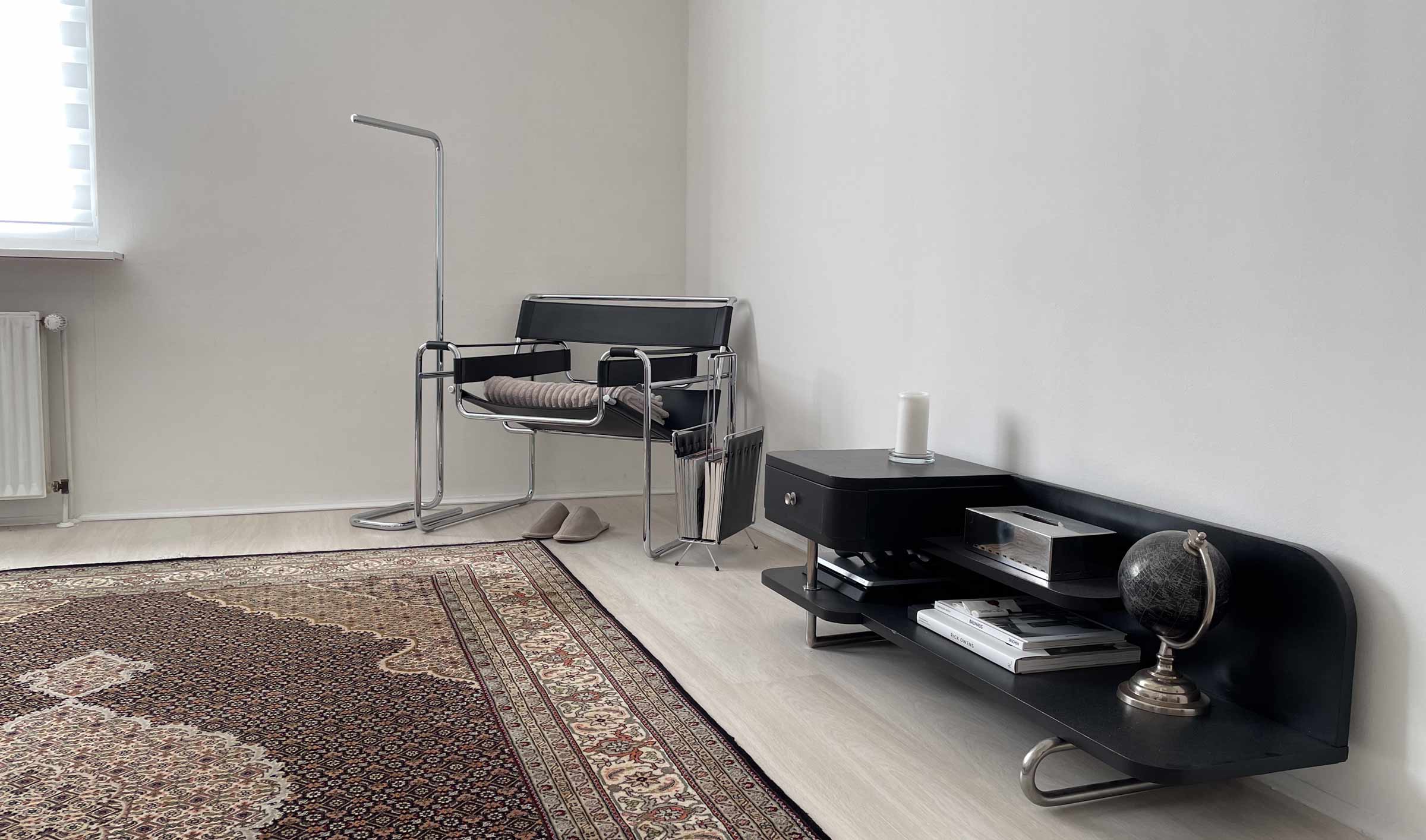 Ein im Bauhaus-Stil eingerichtetes Zimmer mit einem Knoll International Wassily Sessel, einer Thonet Lum Stehleuchte und einem Khademi-Teppich mit Täbriz Mahi Design.