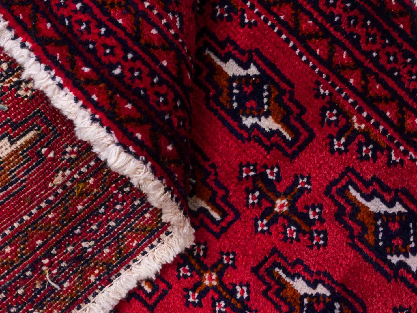 Handgeknüpfter Turkaman Nomadenteppich von Khademi aus Wolle, rot. Bukhara Allover-Design. Von Hand geknüpft in Iran. Größe: 106 cm x 50 cm. Teppichnummer: DB3-1005. Verkauf durch Jupiter Intl.
