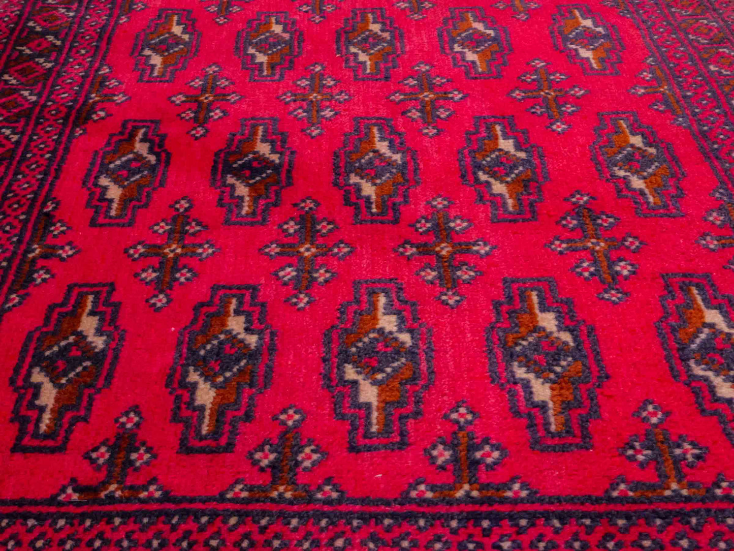 Handgeknüpfter Turkaman Nomadenteppich von Khademi aus Wolle, rot. Bukhara Allover-Design. Von Hand geknüpft in Iran. Größe: 130 cm x 60 cm. Teppichnummer: DB3-1011. Verkauf durch Jupiter Intl.