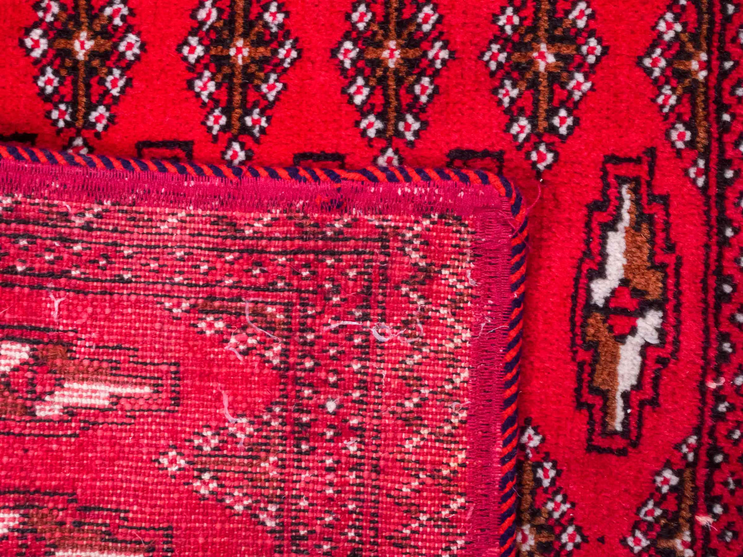 Handgeknüpfter Vintage Turkaman Nomadenteppich von Khademi aus Wolle, rot. Bukhara Allover-Design. Von Hand geknüpft in Iran. Größe: 120 cm x 55 cm. Teppichnummer: DB3-1031. Verkauf durch Jupiter Intl.