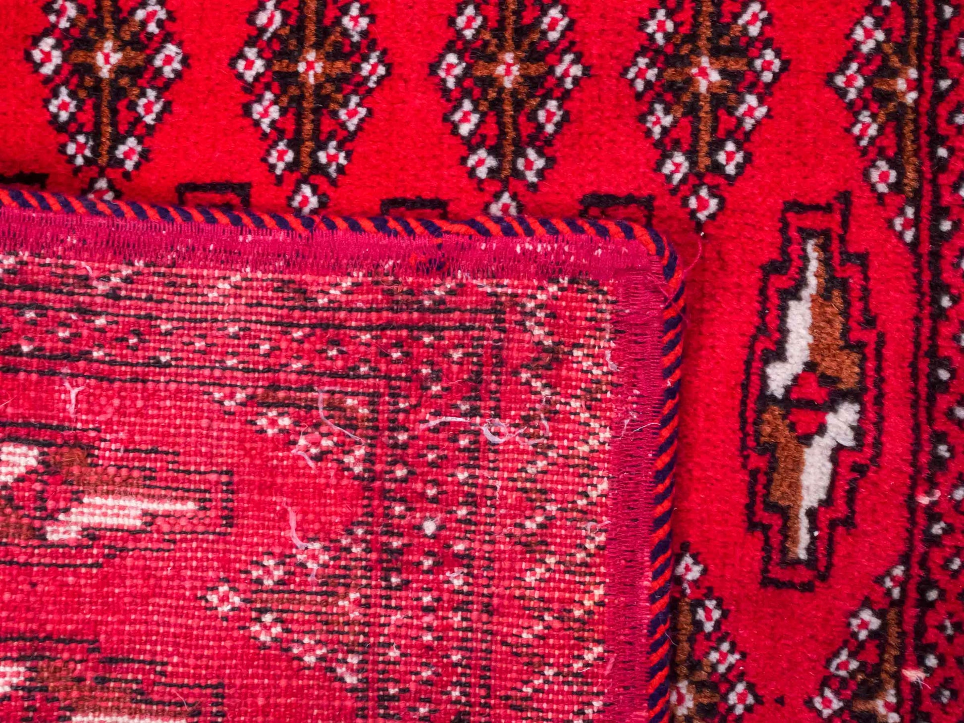 Handgeknüpfter Vintage Turkaman Nomadenteppich von Khademi aus Wolle, rot. Bukhara Allover-Design. Von Hand geknüpft in Iran. Größe: 120 cm x 55 cm. Teppichnummer: DB3-1031. Verkauf durch Jupiter Intl.