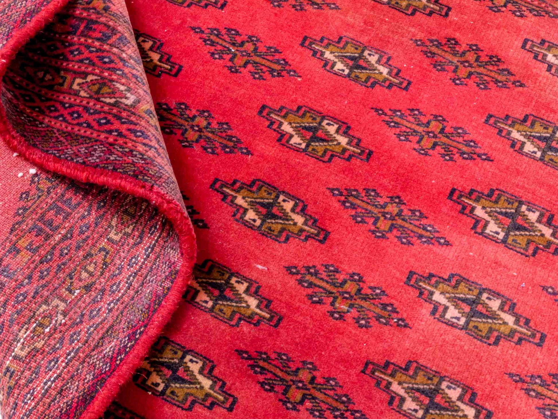 Handgeknüpfter Vintage Turkaman Bukhara Nomadenteppich von Khademi aus Wolle, rot. Bukhara Allover-Design. Von Hand geknüpft in Iran. Größe: 127 cm x 64 cm. Teppichnummer: DB3-1001. Verkauf durch Jupiter Intl.