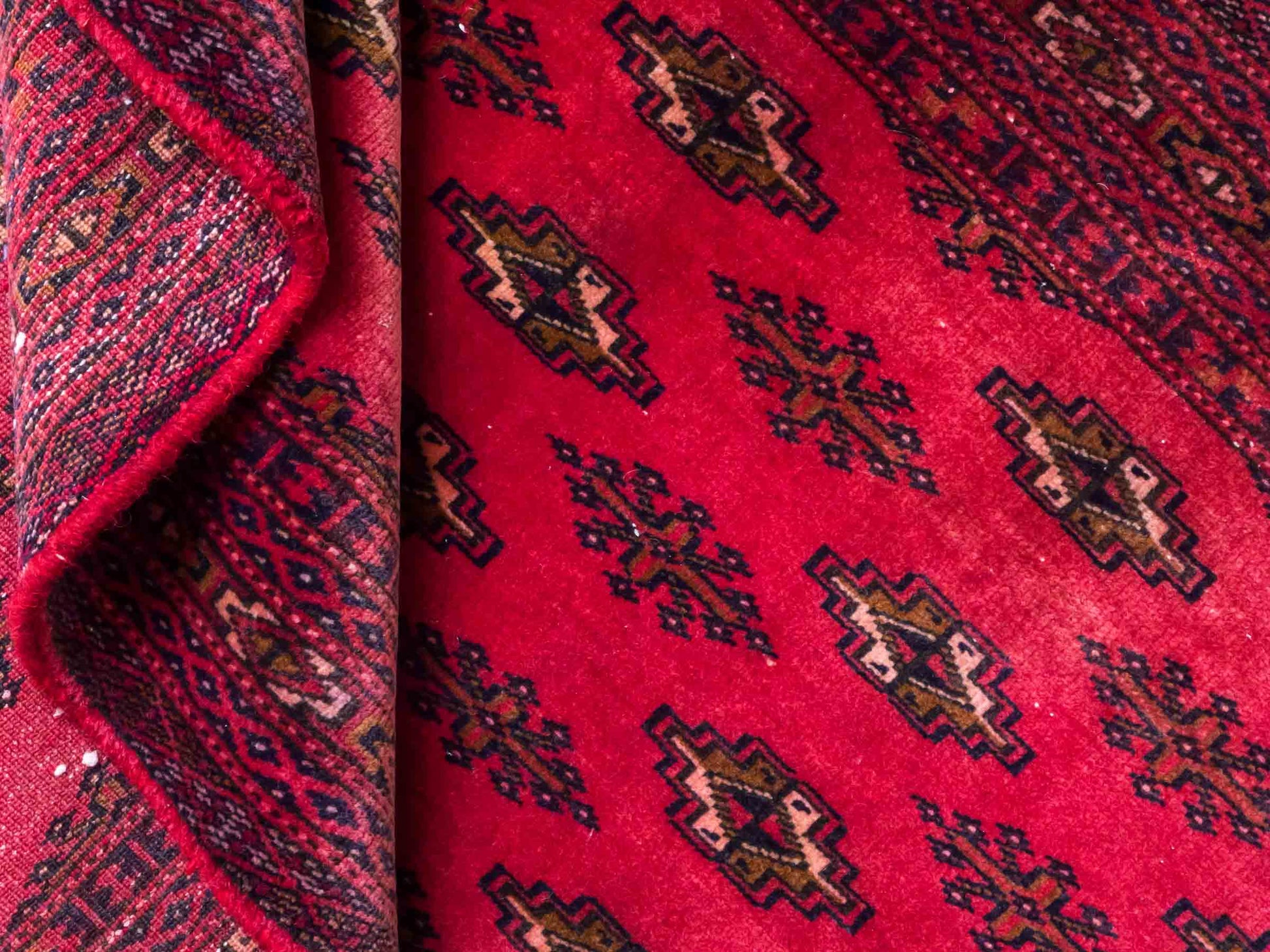 Handgeknüpfter Vintage Turkaman Bukhara Nomadenteppich von Khademi aus Wolle, rot. Bukhara Allover-Design. Von Hand geknüpft in Iran. Größe: 127 cm x 64 cm. Teppichnummer: DB3-1001. Verkauf durch Jupiter Intl.