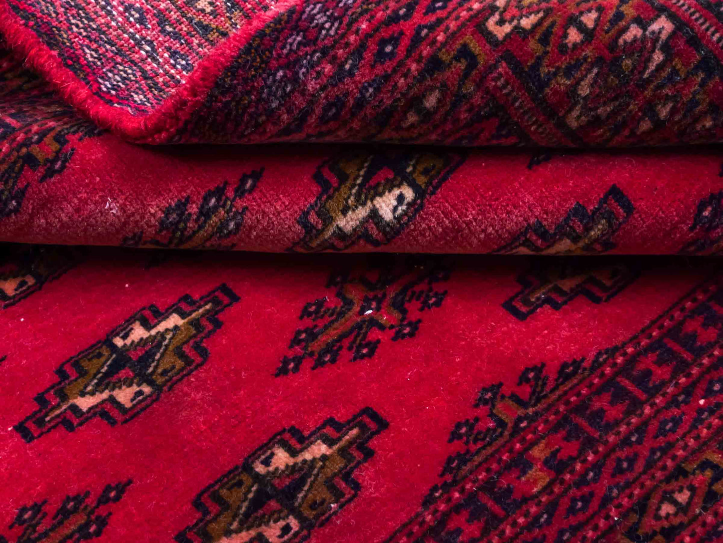 Handgeknüpfter Vintage Turkaman Bukhara Nomadenteppich von Khademi aus Wolle, rot. Bukhara Allover-Design. Von Hand geknüpft in Iran. Größe: 127 cm x 64 cm. Teppichnummer: DB3-1001. Verkauf durch Jupiter Intl.