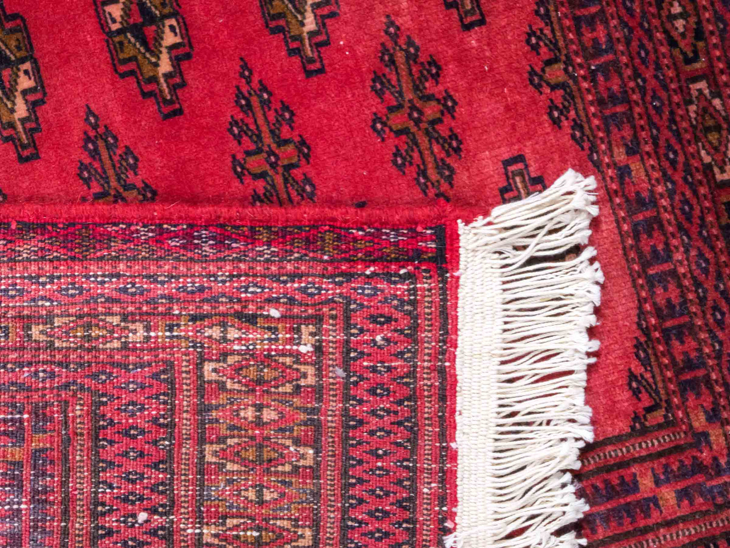 Handgeknüpfter Vintage Turkaman Bukhara Nomadenteppich von Khademi aus Wolle, rot. Bukhara Allover-Design. Von Hand geknüpft in Iran. Größe: 127 cm x 64 cm. Teppichnummer: DB3-1001. Verkauf durch Jupiter Intl.