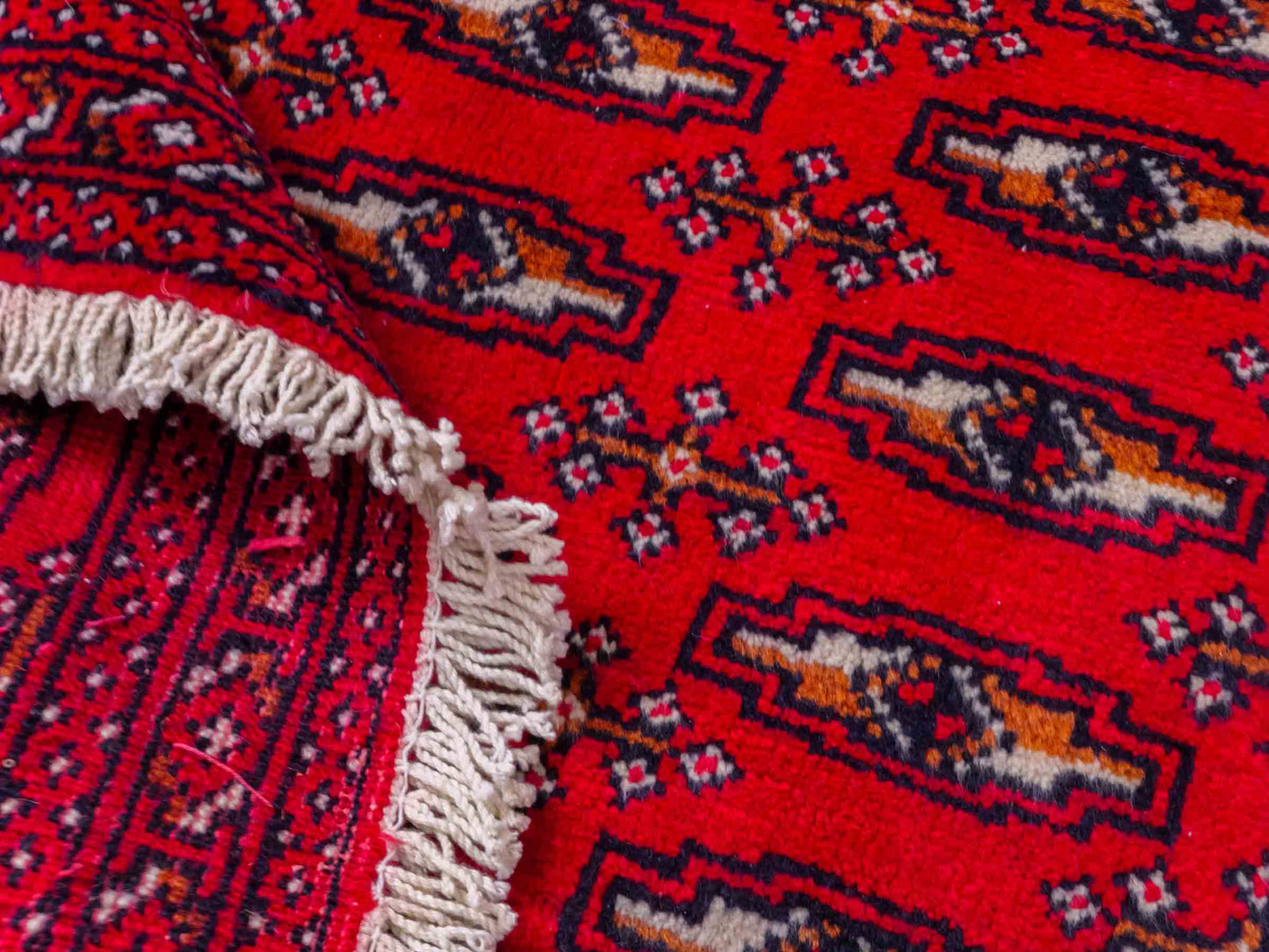 Handgeknüpfter Turkaman Nomadenteppich von Khademi aus Wolle, rot. Bukhara Allover-Design. Von Hand geknüpft in Iran. Größe: 128 cm x 69 cm. Teppichnummer: DB3-1008. Verkauf durch Jupiter Intl.