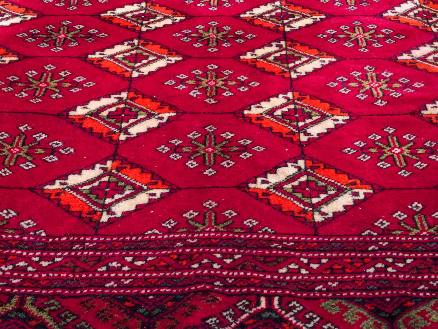Handgeknüpfter Vintage Turkaman Nomadenteppich von Khademi aus Wolle, rot. Bukhara Allover-Design. Von Hand geknüpft in Iran. Größe: 55 cm x 115 cm. Teppichnummer: DB3-1014. Verkauf durch Jupiter Intl.