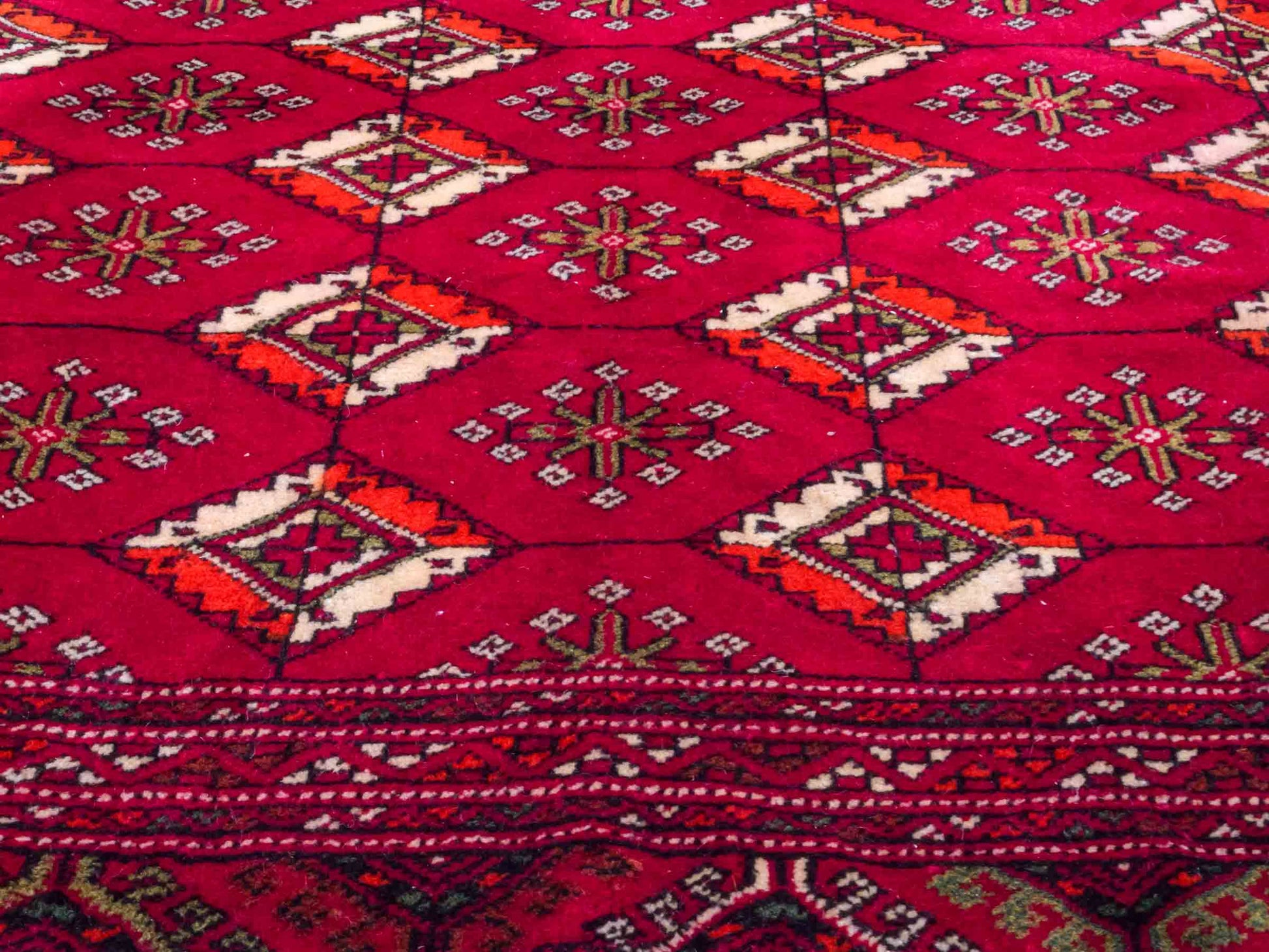 Handgeknüpfter Vintage Turkaman Nomadenteppich von Khademi aus Wolle, rot. Bukhara Allover-Design. Von Hand geknüpft in Iran. Größe: 55 cm x 115 cm. Teppichnummer: DB3-1014. Verkauf durch Jupiter Intl.