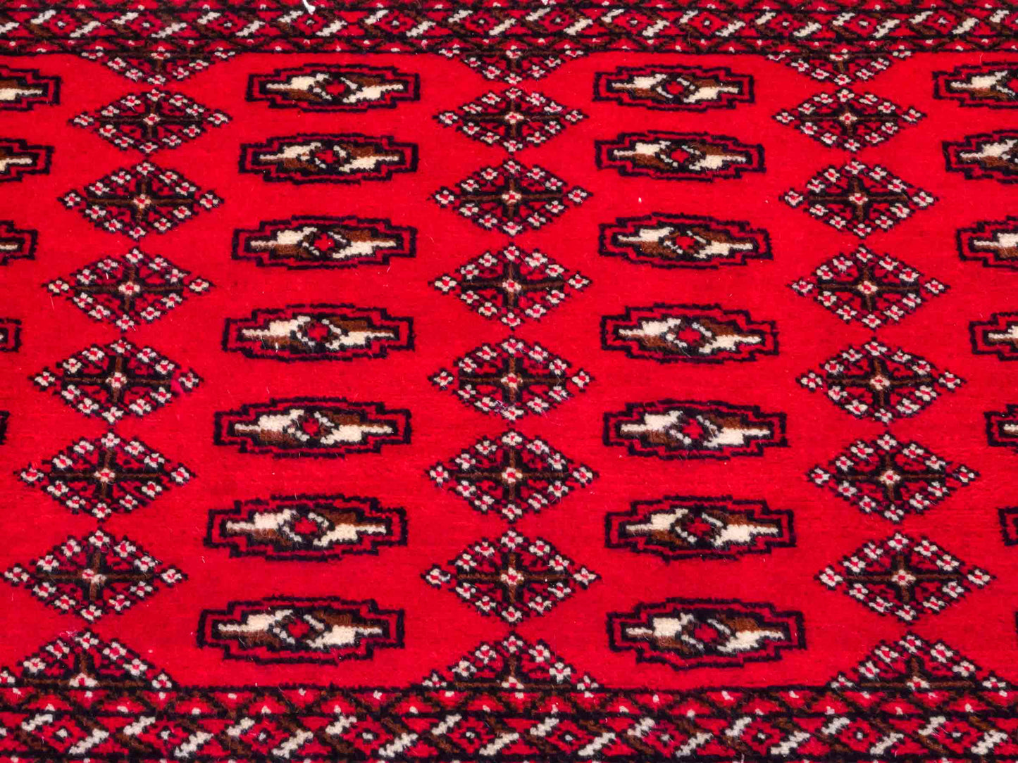 Handgeknüpfter Vintage Turkaman Nomadenteppich von Khademi aus Wolle, rot. Bukhara Allover-Design. Von Hand geknüpft in Iran. Größe: 57 cm x 100 cm. Teppichnummer: DB3-1017. Verkauf durch Jupiter Intl.