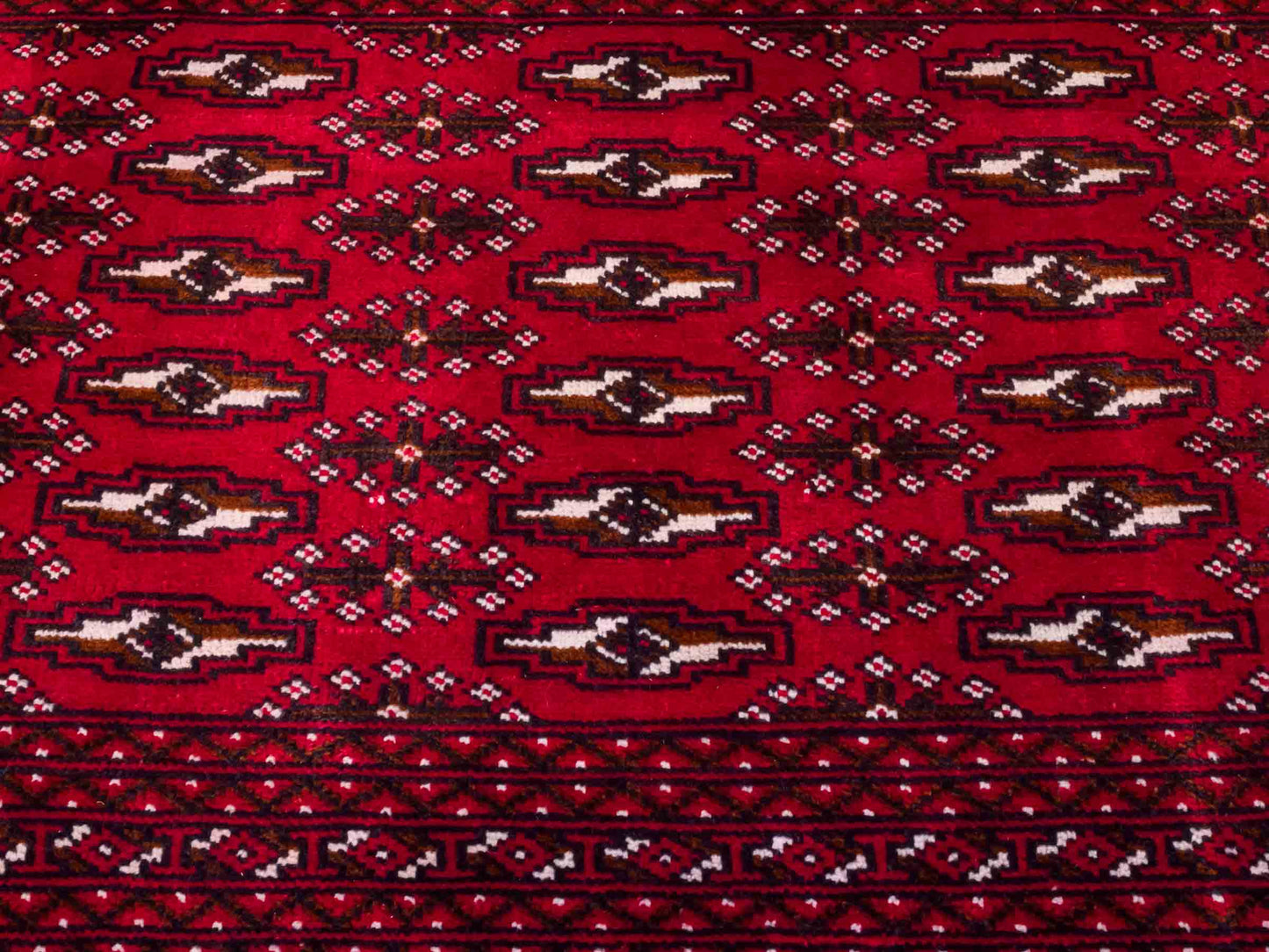 Handgeknüpfter Vintage Turkaman Nomadenteppich von Khademi aus Wolle, rot. Bukhara Allover-Design. Von Hand geknüpft in Iran. Größe: 60 cm x 115 cm. Teppichnummer: DB3-1016. Verkauf durch Jupiter Intl.