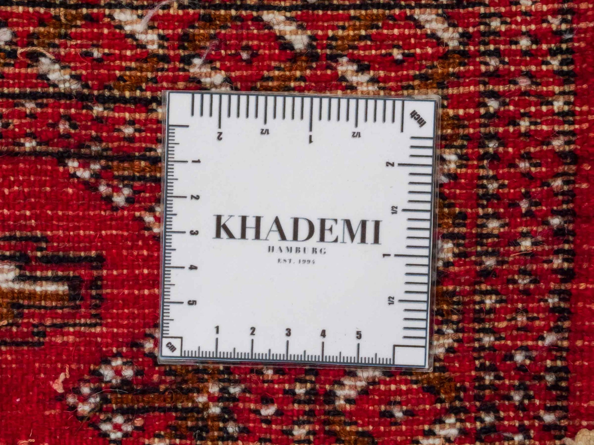 Handgeknüpfter Vintage Turkaman Nomadenteppich von Khademi aus Wolle, rot. Bukhara Allover-Design. Von Hand geknüpft in Iran. Größe: 53 cm x 110 cm. Teppichnummer: DB3-1022. Verkauf durch Jupiter Intl.