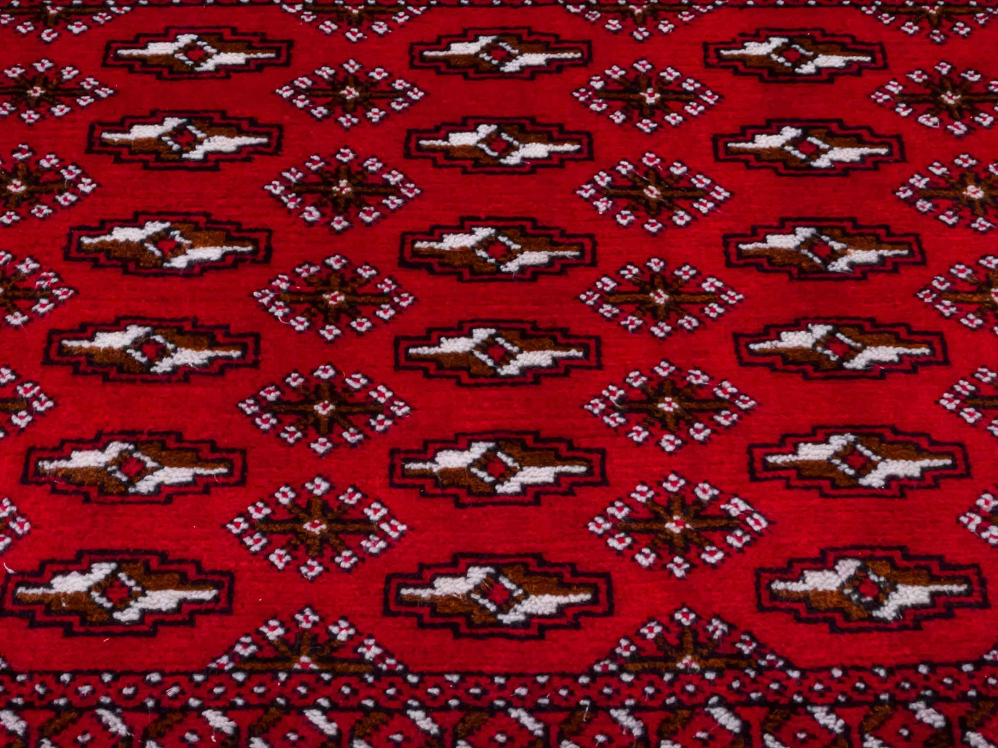 Handgeknüpfter Vintage Turkaman Nomadenteppich von Khademi aus Wolle, rot. Bukhara Allover-Design. Von Hand geknüpft in Iran. Größe: 53 cm x 110 cm. Teppichnummer: DB3-1022. Verkauf durch Jupiter Intl.