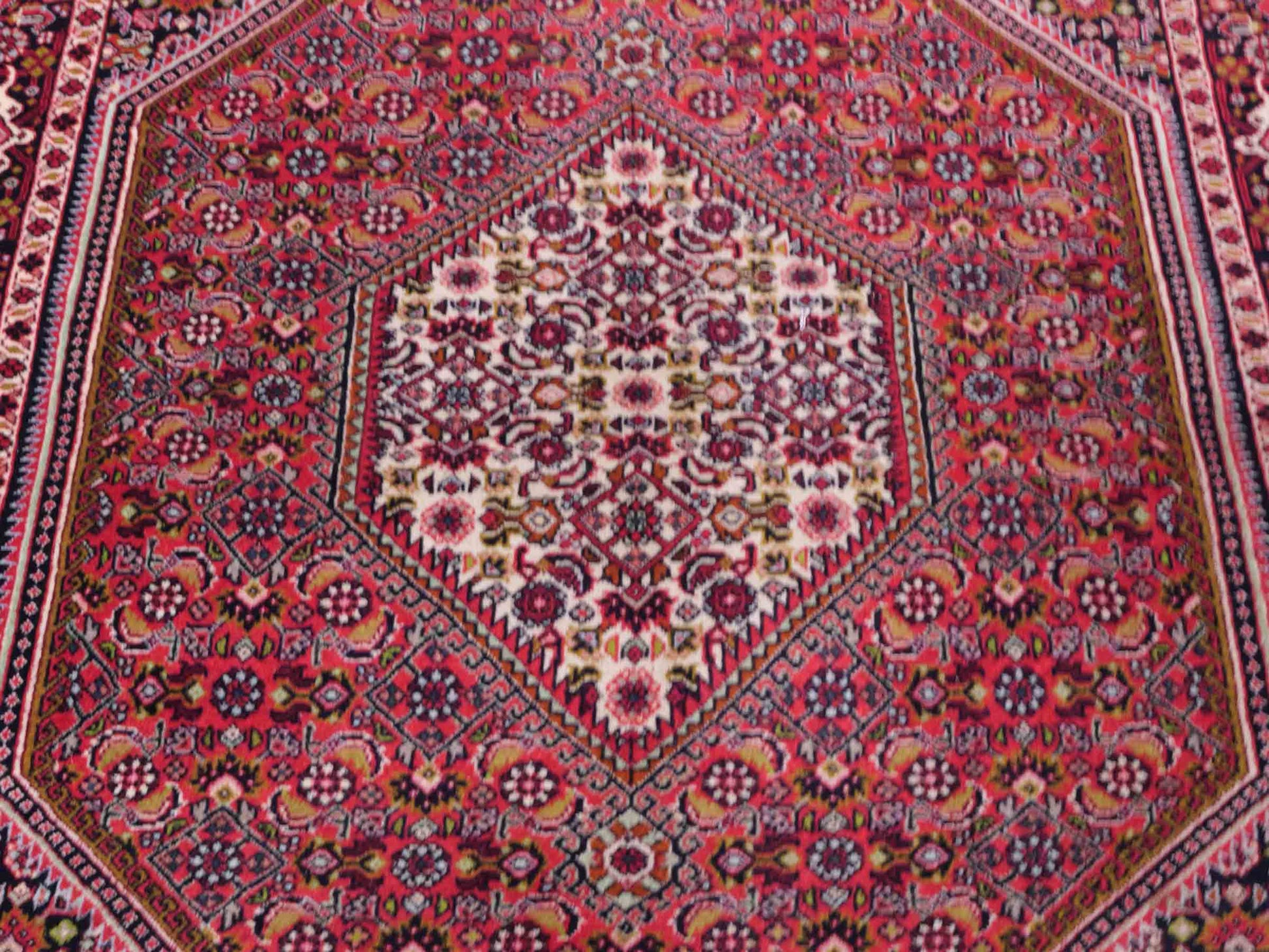 Handgeknüpfter Bidjar Perserteppich von Khademi aus Wolle, rot. Feiner, kurdischer Dorfteppich mit geometrischem Medaillon. Orientteppich, von Hand geknüpft in Iran. Größe: 176 cm x 109 cm. Teppichnummer: SB3-1133 | Jupiter Intl.