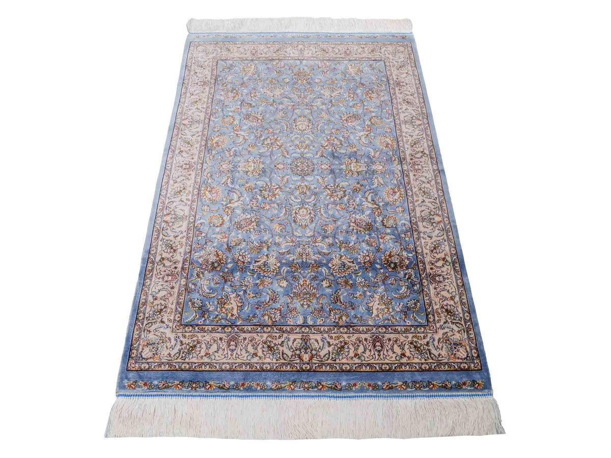 Ghom Maschinenteppich "Afridun" 120 x 80 cm, durchgemustert, aus pflanzlicher Seide (Viskose), Hellblau-Cremeweiß. Teppichnummer: V2BL096H. Persian Luxury Collection by Khademi. Made in Iran / Persia – Vertrieb durch JUPITER Intl.