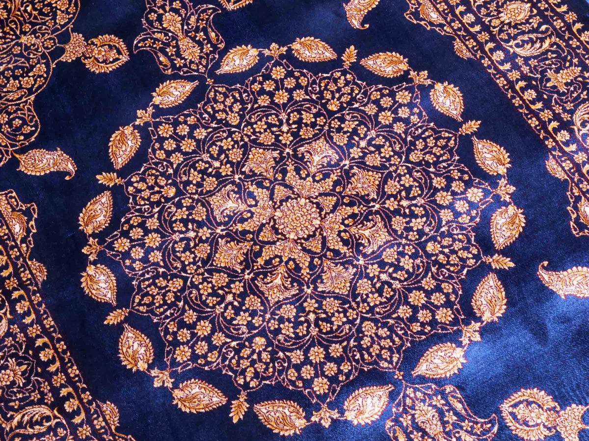 Ghom Maschinenteppich "Anahita" 120 x 80 cm aus pflanzlicher Seide (Viskose) mit Medaillon, Marineblau-Gold. Teppichnummer: V3NY096M. Persian Luxury Collection by Khademi. Made in Iran / Persia – Vertrieb durch JUPITER Intl.
