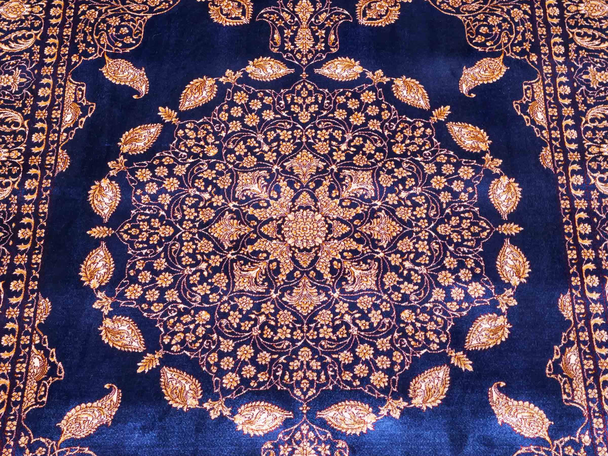 Ghom Maschinenteppich "Anahita" 120 x 80 cm aus pflanzlicher Seide (Viskose) mit Medaillon, Marineblau-Gold. Teppichnummer: V3NY096M. Persian Luxury Collection by Khademi. Made in Iran / Persia – Vertrieb durch JUPITER Intl.