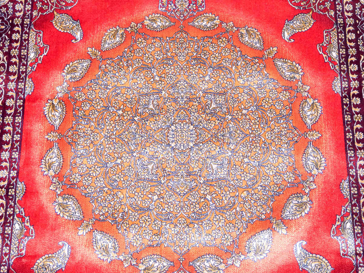 Ghom Maschinenteppich "Anahita" 120 x 80 cm aus pflanzlicher Seide (Viskose) mit Medaillon, Rot-Gold. Teppichnummer: V3RG096M. Persian Luxury Collection by Khademi. Made in Iran / Persia – Vertrieb durch JUPITER Intl.