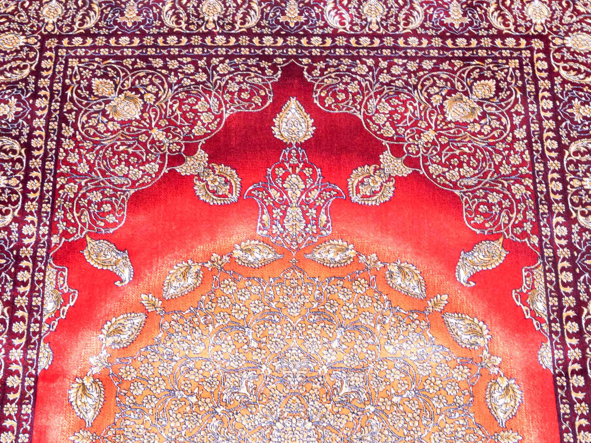 Ghom Maschinenteppich "Anahita" 120 x 80 cm aus pflanzlicher Seide (Viskose) mit Medaillon, Rot-Gold. Teppichnummer: V3RG096M. Persian Luxury Collection by Khademi. Made in Iran / Persia – Vertrieb durch JUPITER Intl.