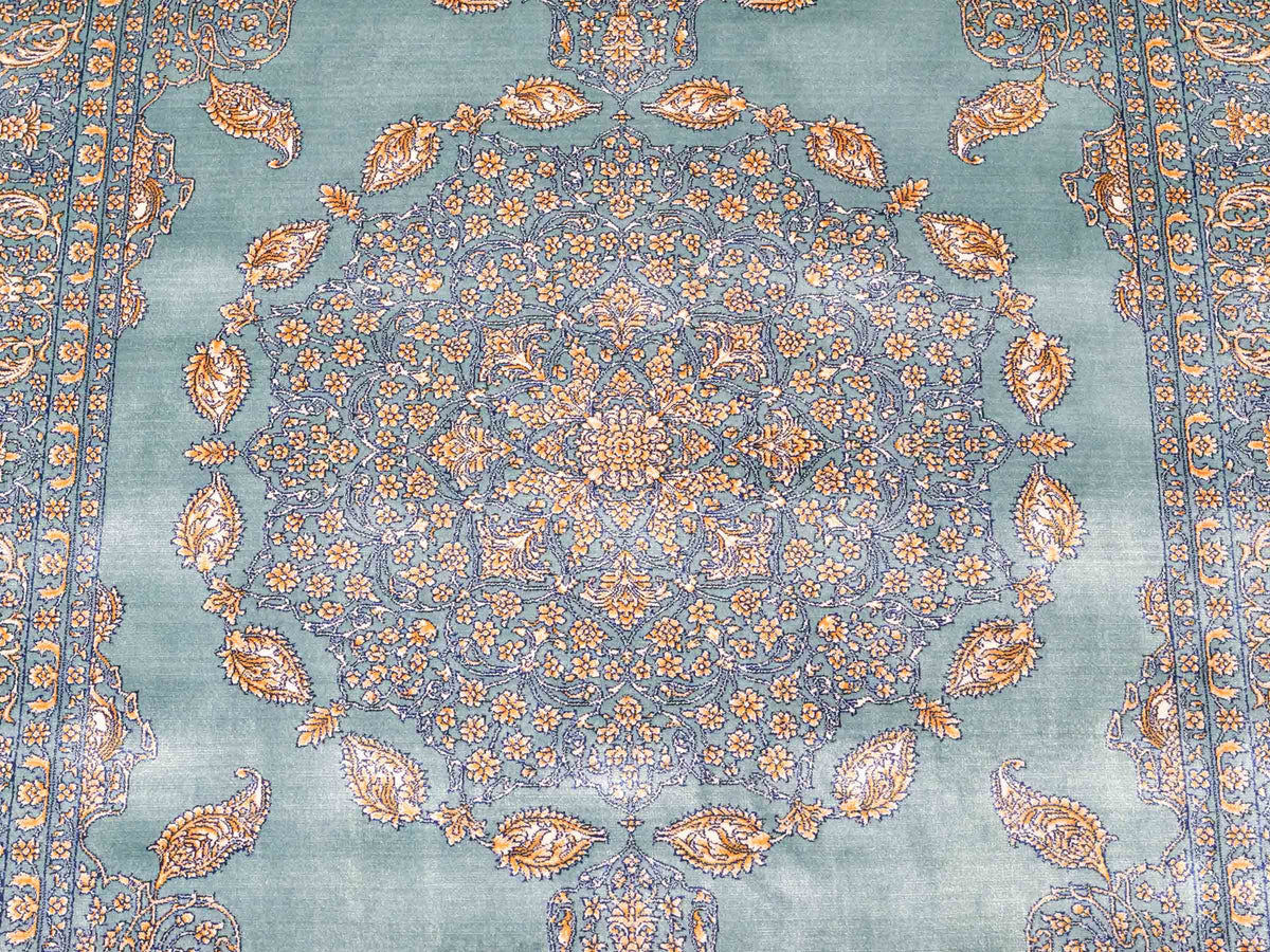 Ghom Maschinenteppich "Anahita" 120 x 80 cm aus pflanzlicher Seide (Viskose) mit Medaillon, Türkis-Gold. Teppichnummer: V3TE096M. Persian Luxury Collection by Khademi. Made in Iran / Persia – Vertrieb durch JUPITER Intl.