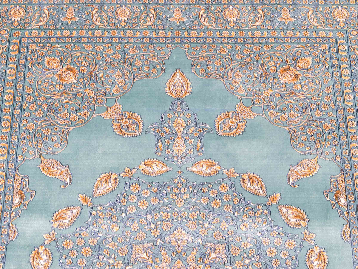 Ghom Maschinenteppich "Anahita" 120 x 80 cm aus pflanzlicher Seide (Viskose) mit Medaillon, Türkis-Gold. Teppichnummer: V3TE096M. Persian Luxury Collection by Khademi. Made in Iran / Persia – Vertrieb durch JUPITER Intl.