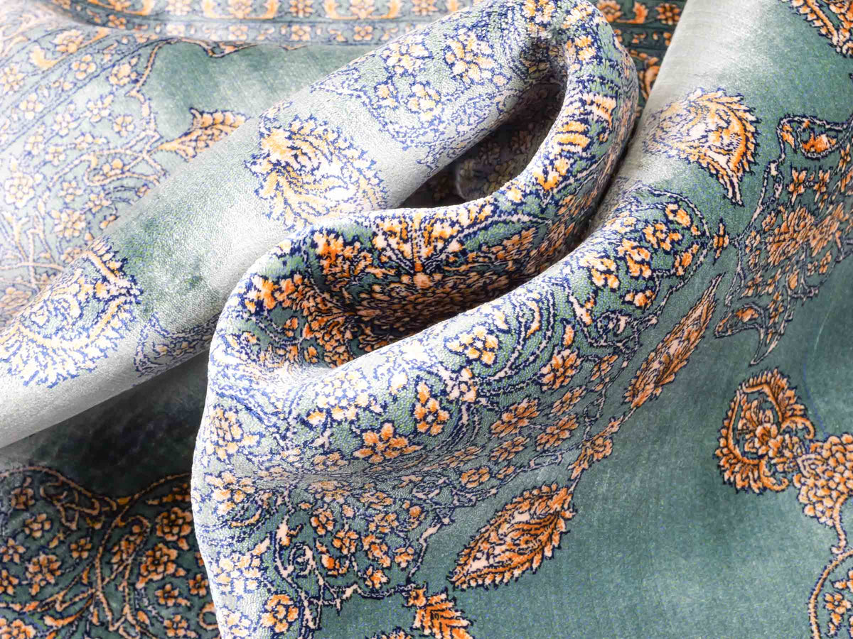 Ghom Maschinenteppich "Anahita" 120 x 80 cm aus pflanzlicher Seide (Viskose) mit Medaillon, Türkis-Gold. Teppichnummer: V3TE096M. Persian Luxury Collection by Khademi. Made in Iran / Persia – Vertrieb durch JUPITER Intl.