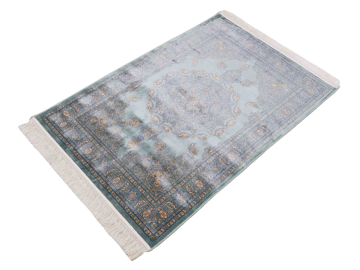 Ghom Maschinenteppich "Anahita" 120 x 80 cm aus pflanzlicher Seide (Viskose) mit Medaillon, Türkis-Gold. Teppichnummer: V3TE096M. Persian Luxury Collection by Khademi. Made in Iran / Persia – Vertrieb durch JUPITER Intl.