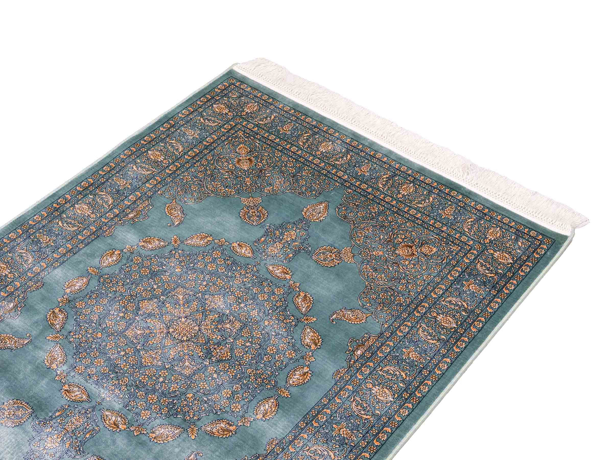 Ghom Maschinenteppich "Anahita" 120 x 80 cm aus pflanzlicher Seide (Viskose) mit Medaillon, Türkis-Gold. Teppichnummer: V3TE096M. Persian Luxury Collection by Khademi. Made in Iran / Persia – Vertrieb durch JUPITER Intl.