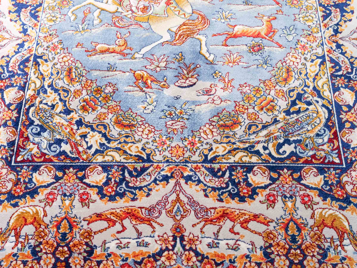 Ghom Maschinenteppich "Banu" 90 x 60 cm, mit Jagdmotiv, Hellblau, aus pflanzlicher Seide (Viskose), Hand-Finished. Teppichnummer: V13BL054H. Persian Luxury Collection by Khademi. Made in Iran / Persia – Vertrieb durch JUPITER Intl.