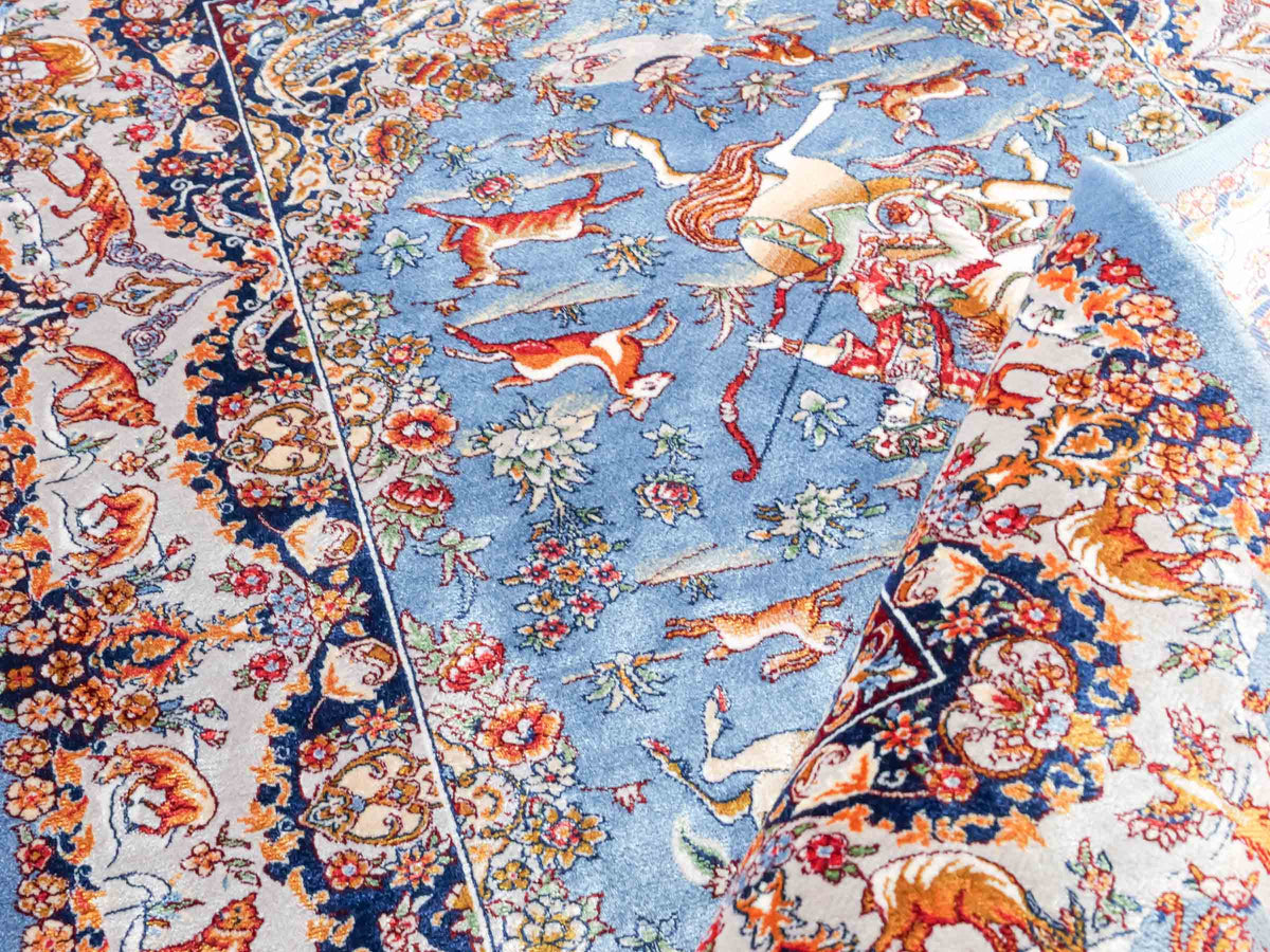 Ghom Maschinenteppich "Banu" 90 x 60 cm, mit Jagdmotiv, Hellblau, aus pflanzlicher Seide (Viskose), Hand-Finished. Teppichnummer: V13BL054H. Persian Luxury Collection by Khademi. Made in Iran / Persia – Vertrieb durch JUPITER Intl.