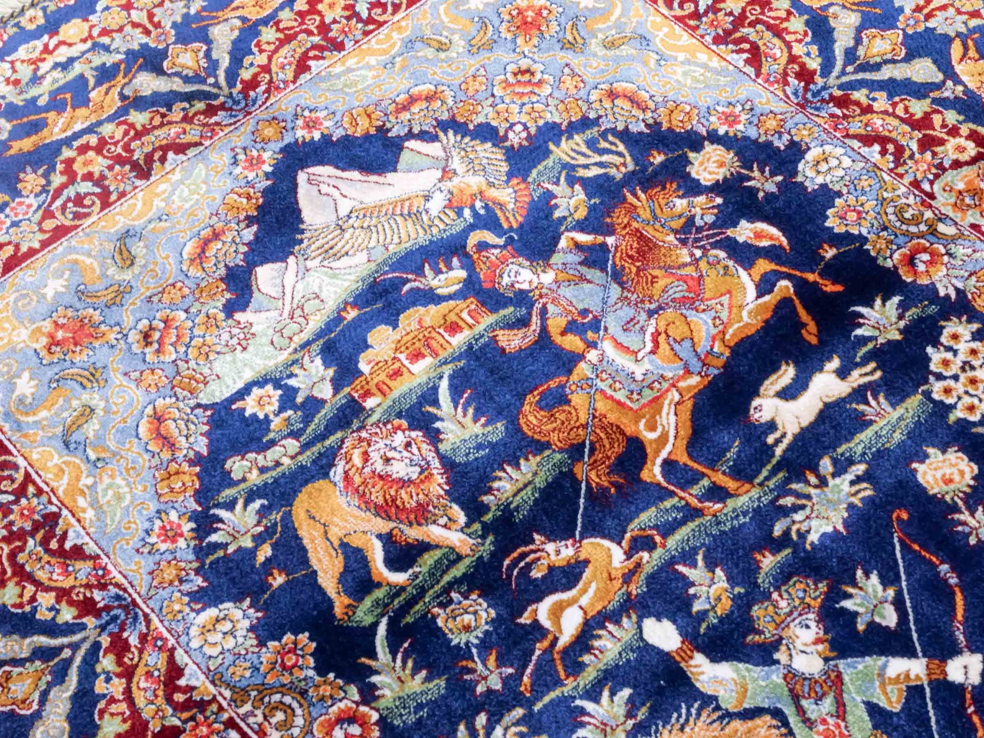 Ghom Maschinenteppich "Banu" 90 x 60 cm aus pflanzlicher Seide (Viskose) mit Jagdmotiv, Marineblau. Teppichnummer: V13NY054H. Persian Luxury Collection by Khademi. Made in Iran / Persia – Vertrieb durch JUPITER Intl.