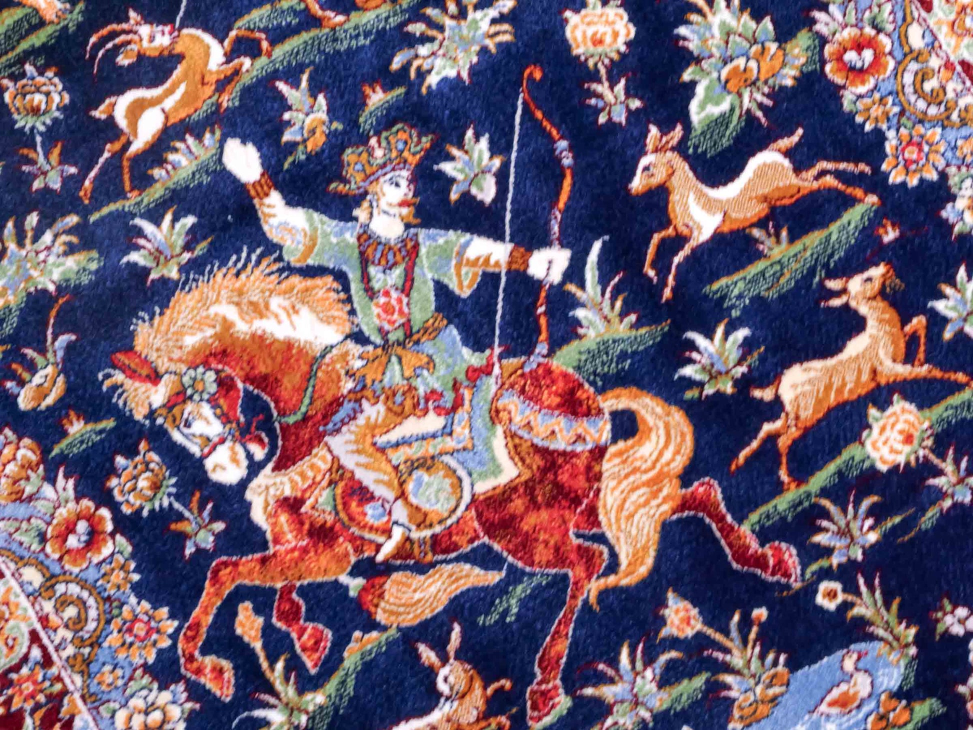 Ghom Maschinenteppich "Banu" 90 x 60 cm aus pflanzlicher Seide (Viskose) mit Jagdmotiv, Marineblau. Teppichnummer: V13NY054H. Persian Luxury Collection by Khademi. Made in Iran / Persia – Vertrieb durch JUPITER Intl.