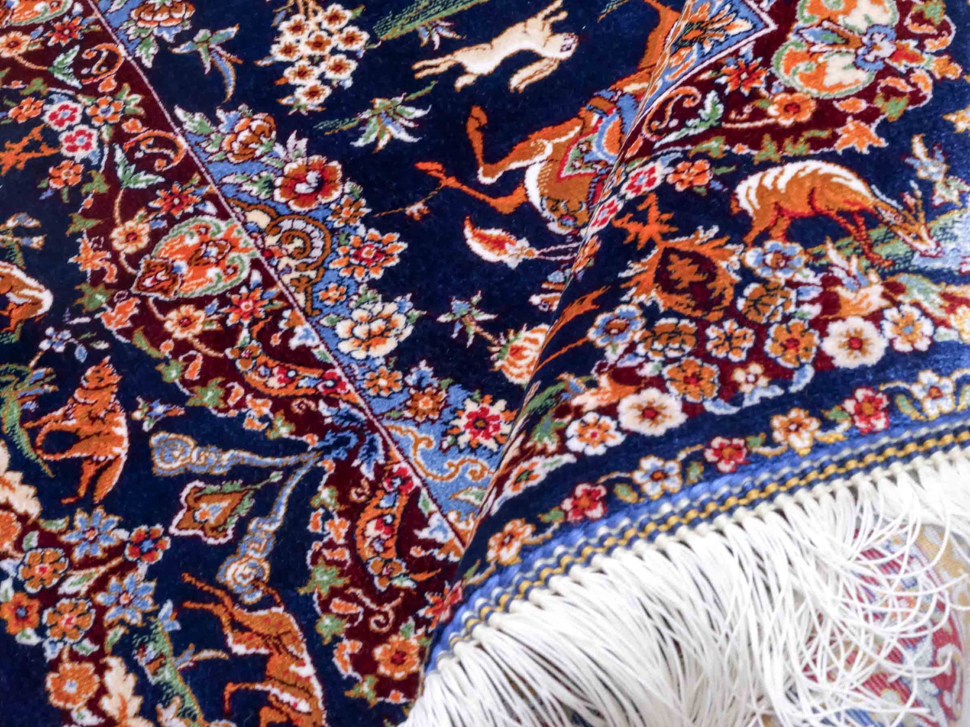 Ghom Maschinenteppich "Banu" 90 x 60 cm aus pflanzlicher Seide (Viskose) mit Jagdmotiv, Marineblau. Teppichnummer: V13NY054H. Persian Luxury Collection by Khademi. Made in Iran / Persia – Vertrieb durch JUPITER Intl.