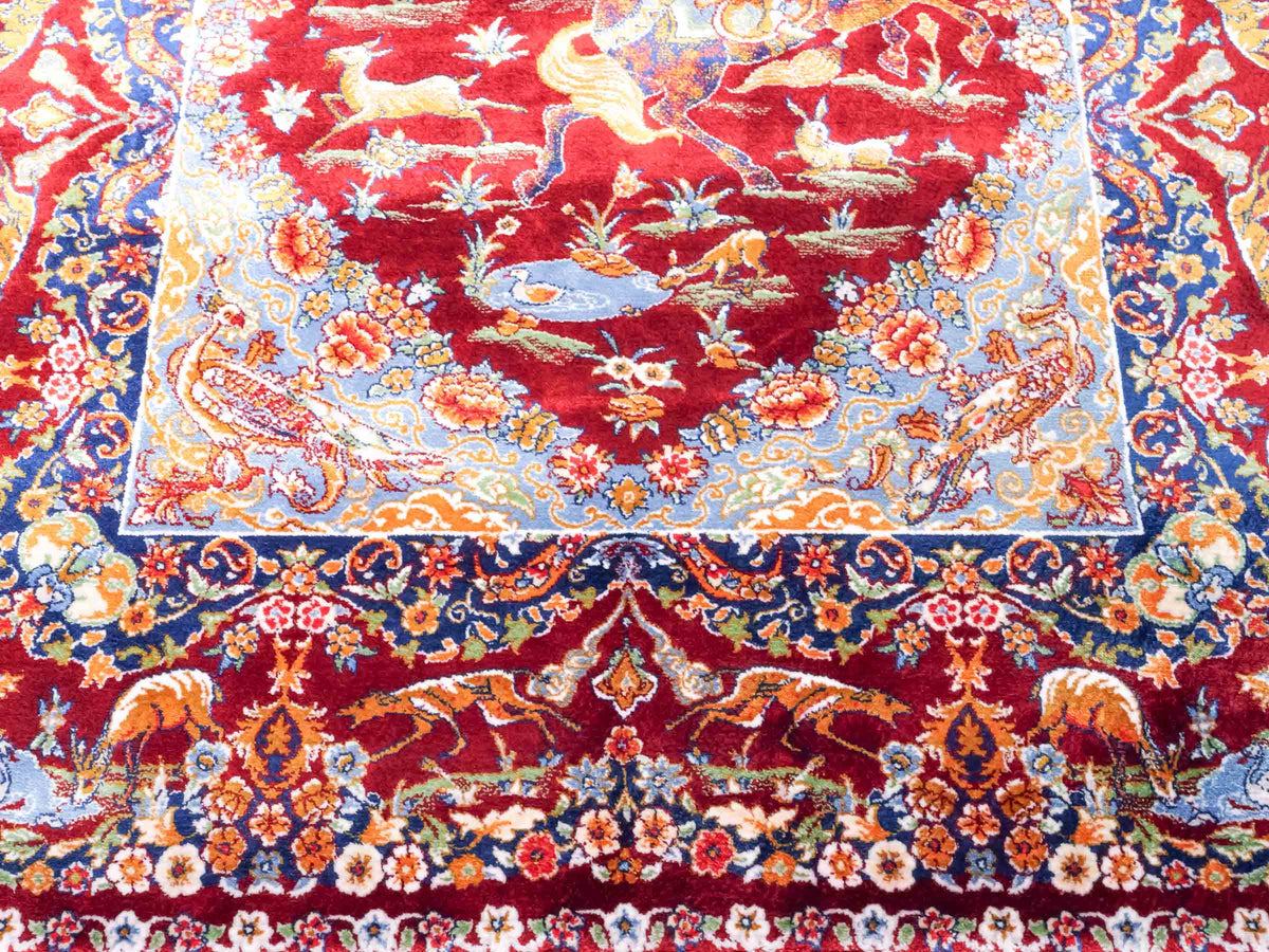 Ghom Maschinenteppich "Banu" 90 x 60 cm, mit Jagdmotiv, Rot, aus pflanzlicher Seide (Viskose), Hand-Finished. Teppichnummer: V13RD054H. Persian Luxury Collection by Khademi. Made in Iran / Persia – Vertrieb durch JUPITER Intl.