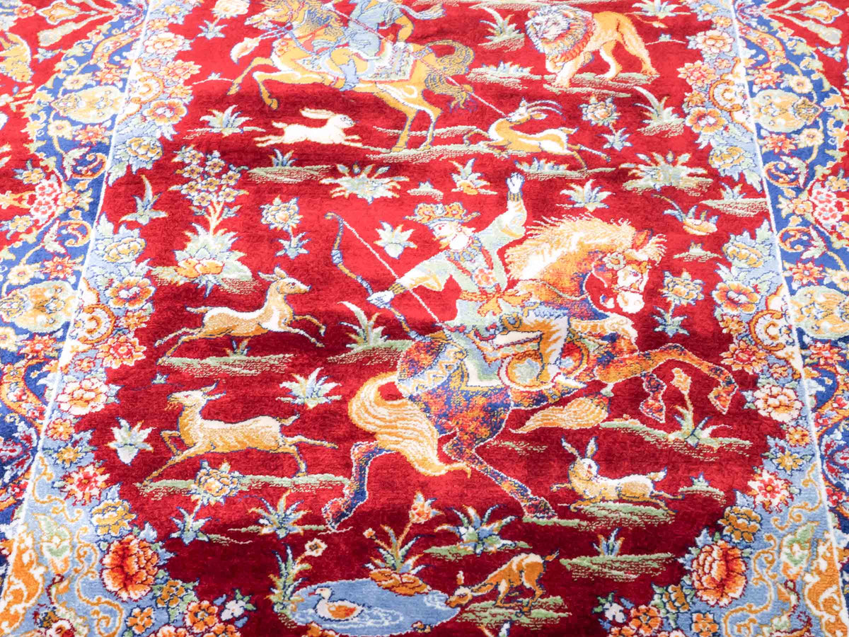 Ghom Maschinenteppich "Banu" 90 x 60 cm, mit Jagdmotiv, Rot, aus pflanzlicher Seide (Viskose), Hand-Finished. Teppichnummer: V13RD054H. Persian Luxury Collection by Khademi. Made in Iran / Persia – Vertrieb durch JUPITER Intl.