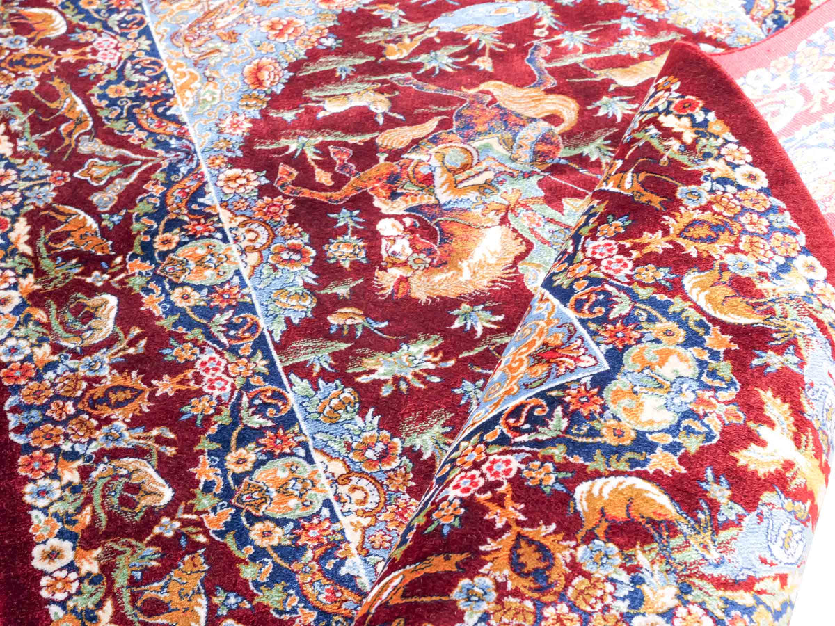 Ghom Maschinenteppich "Banu" 90 x 60 cm, mit Jagdmotiv, Rot, aus pflanzlicher Seide (Viskose), Hand-Finished. Teppichnummer: V13RD054H. Persian Luxury Collection by Khademi. Made in Iran / Persia – Vertrieb durch JUPITER Intl.
