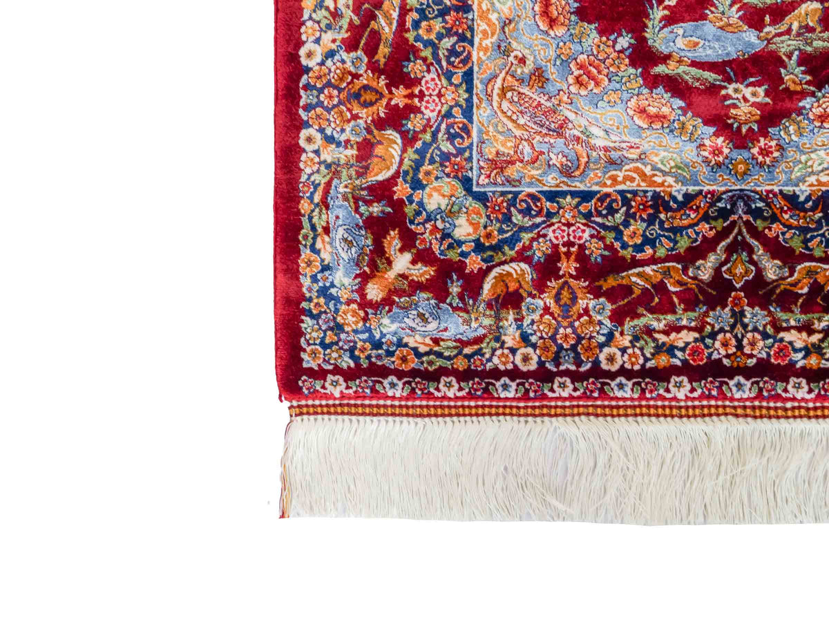 Ghom Maschinenteppich "Banu" 90 x 60 cm, mit Jagdmotiv, Rot, aus pflanzlicher Seide (Viskose), Hand-Finished. Teppichnummer: V13RD054H. Persian Luxury Collection by Khademi. Made in Iran / Persia – Vertrieb durch JUPITER Intl.