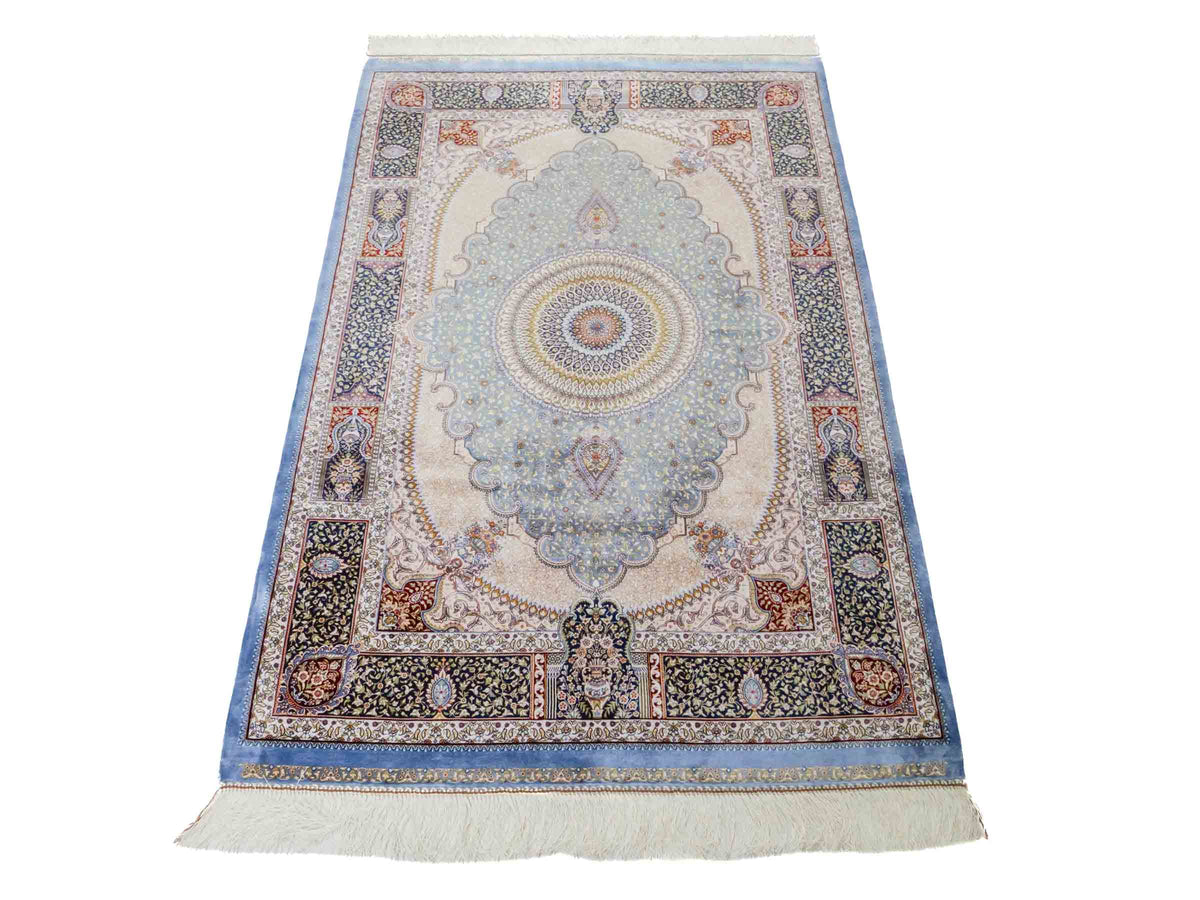 Ghom Maschinenteppich "Bijan" 150 x 100 cm aus pflanzlicher Seide (Viskose) mit Medaillon, Hellblau / Blau. Teppichnummer: V16BN150H. Persian Luxury Collection by Khademi. Made in Iran / Persia – Vertrieb durch JUPITER Intl.