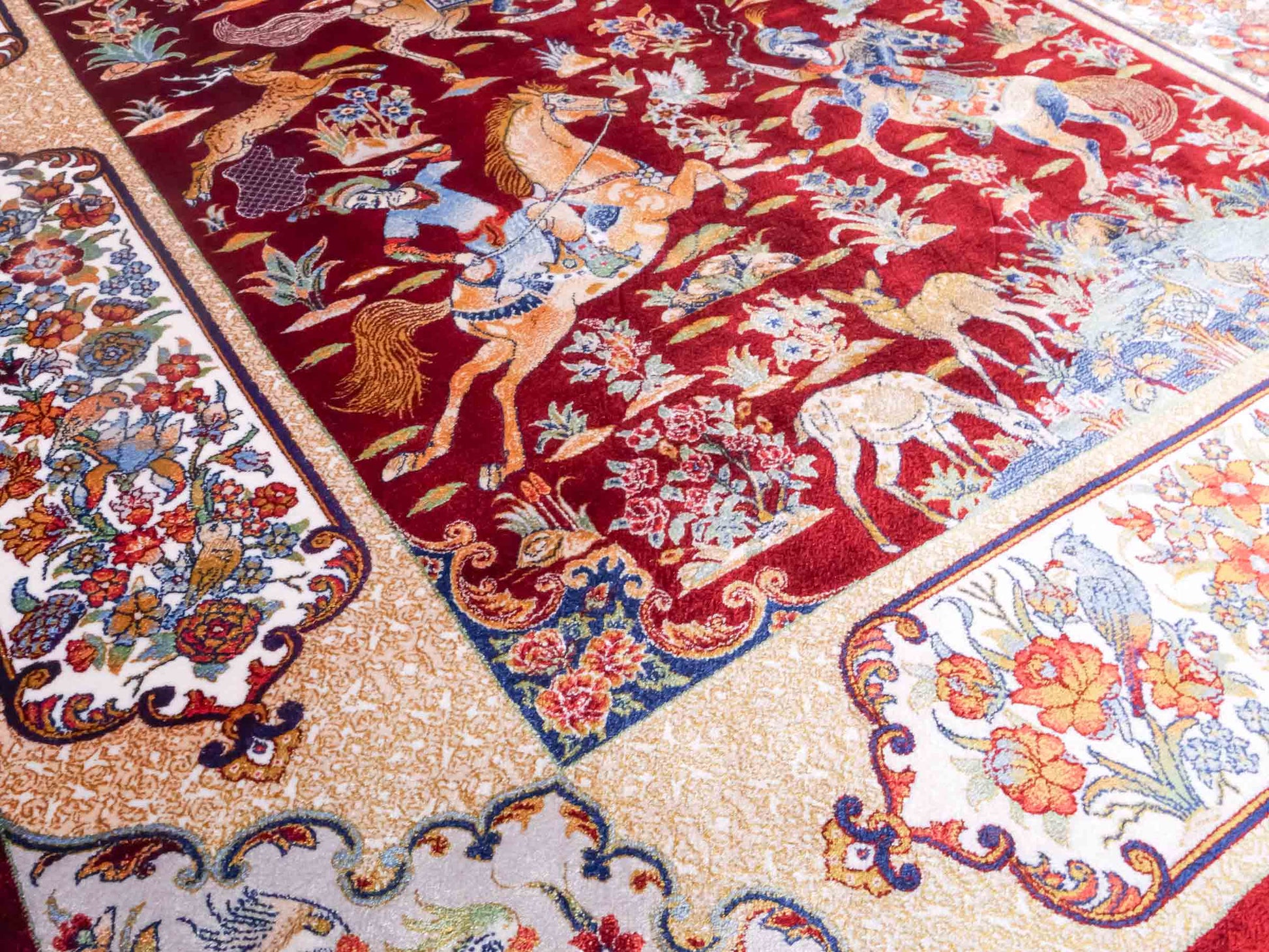 Ghom Maschinenteppich "Fariborz" 120 x 80 cm aus pflanzlicher Seide (Viskose) mit Jagdmotiv, Rot-Beige. Teppichnummer: V25RB096H. Persian Luxury Collection by Khademi. Made in Iran / Persia – Vertrieb durch JUPITER Intl.