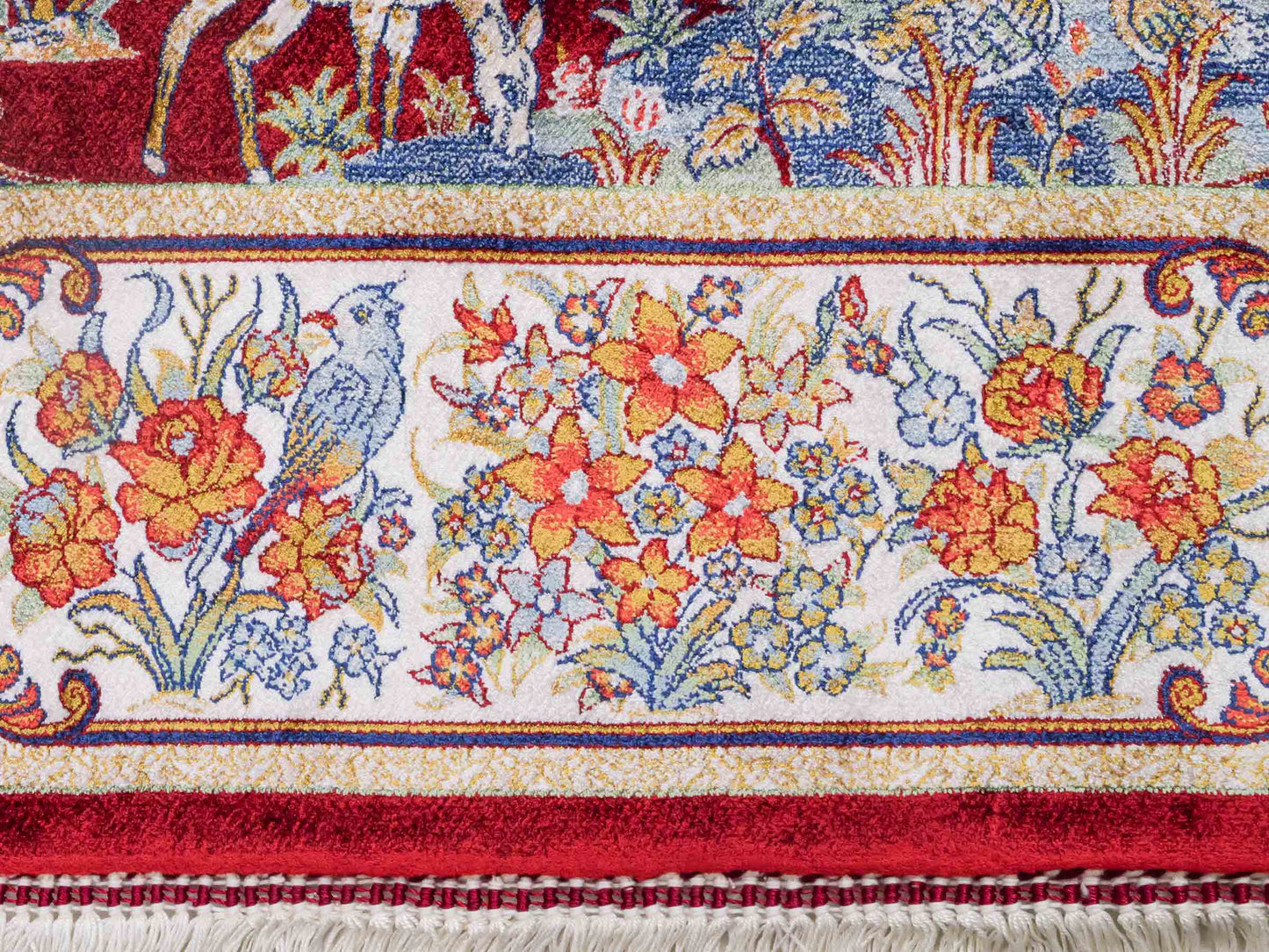 Ghom Maschinenteppich "Fariborz" 120 x 80 cm aus pflanzlicher Seide (Viskose) mit Jagdmotiv, Rot-Beige. Teppichnummer: V25RB096H. Persian Luxury Collection by Khademi. Made in Iran / Persia – Vertrieb durch JUPITER Intl.