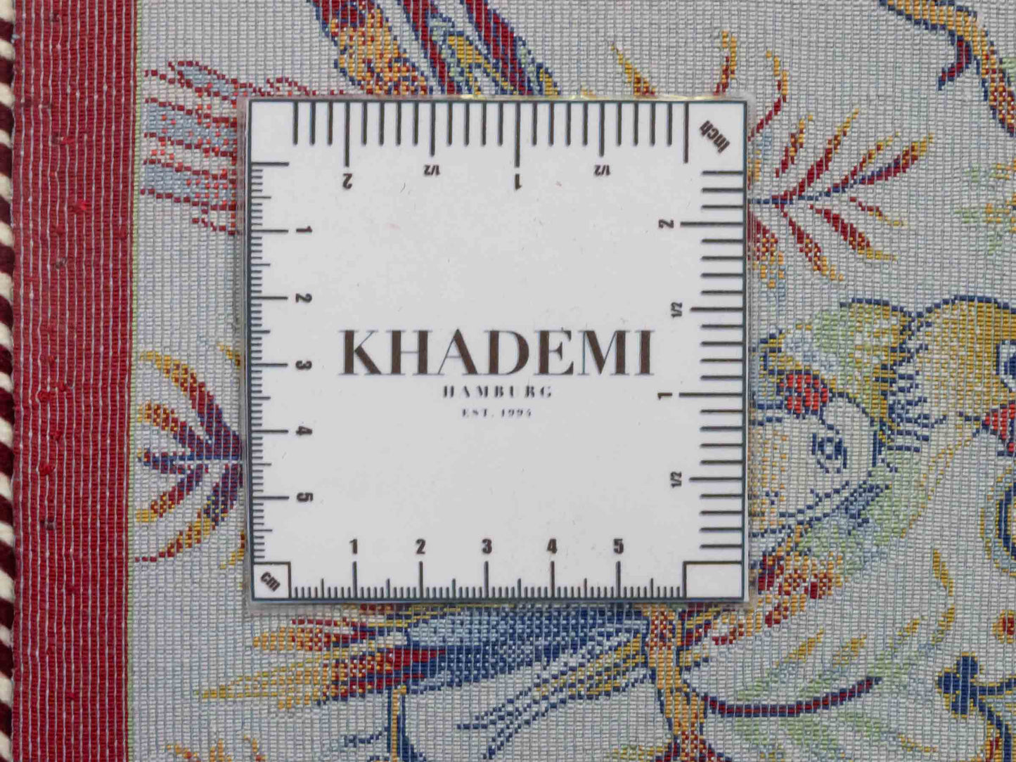 Ghom Maschinenteppich "Fariborz" 120 x 80 cm aus pflanzlicher Seide (Viskose) mit Jagdmotiv, Rot-Beige. Teppichnummer: V25RB096H. Persian Luxury Collection by Khademi. Made in Iran / Persia – Vertrieb durch JUPITER Intl.