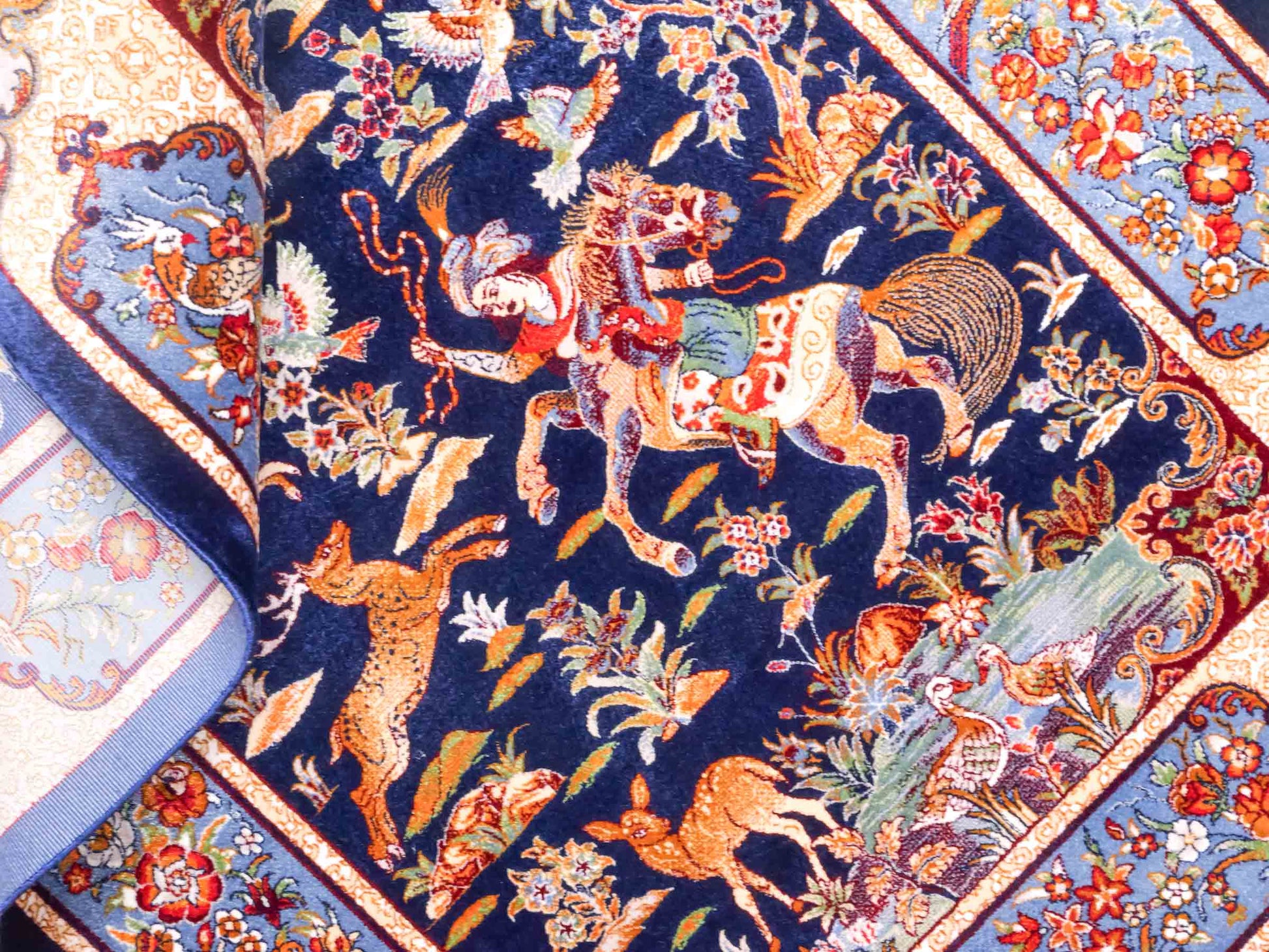 Ghom Maschinenteppich "Fariborz" 90 x 60 cm aus pflanzlicher Seide (Viskose) mit Jagdmotiv, Navy-Blau. Teppichnummer: V25NY054H. Persian Luxury Collection by Khademi. Made in Iran / Persia – Vertrieb durch JUPITER Intl.