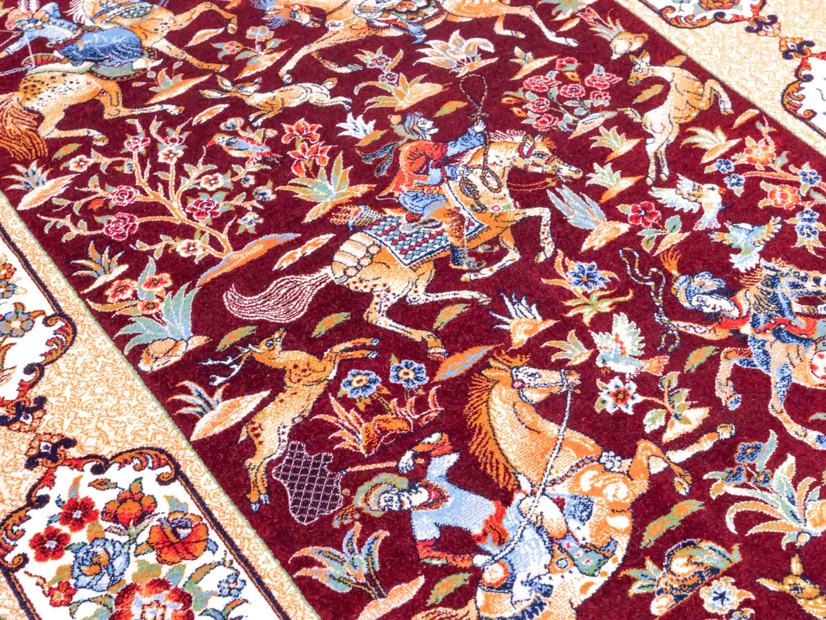 Ghom Maschinenteppich "Fariborz" 90 x 60 cm, mit Jagdmotiv, Rot-Beige, aus pflanzlicher Seide (Viskose), Hand-Finished. Teppichnummer: V25RB054H. Persian Luxury Collection by Khademi. Made in Iran / Persia – Vertrieb durch JUPITER Intl.